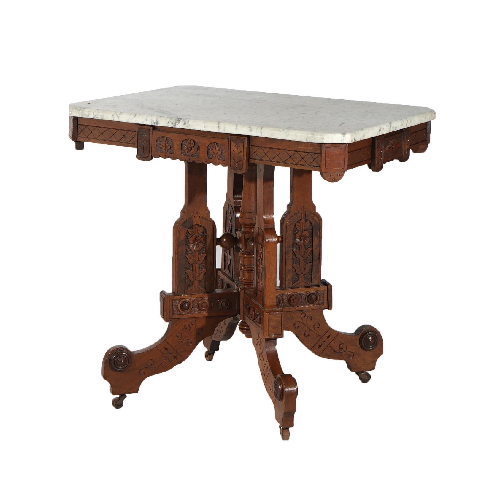 An antique Eastlake Aesthetic parlor table offers clipped corner marble top over walnut base having carved foliate and floral elements throughout and raised on stylized scroll form legs, c1880

Measures - 30.5