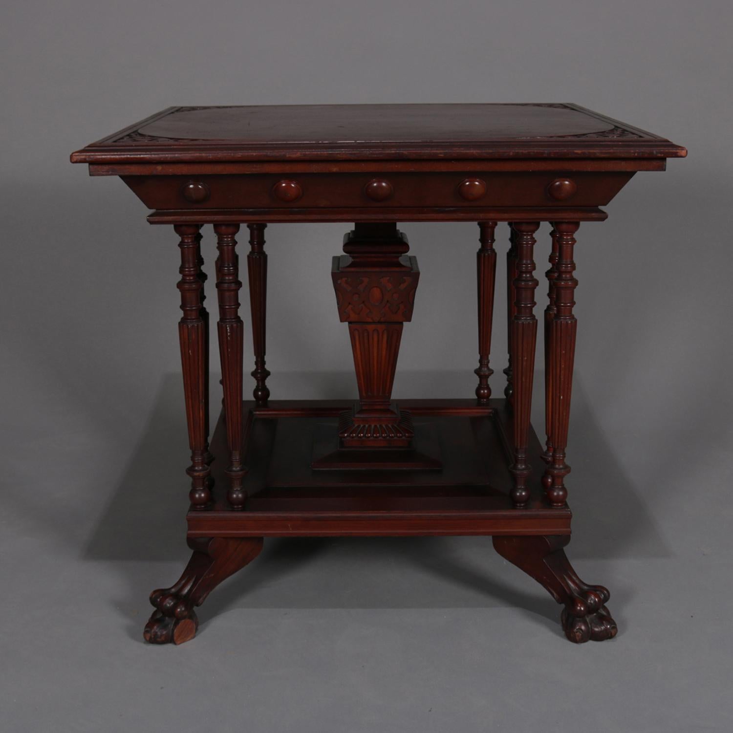 An antique Eastlake Regina music box table features carved mahogany construction with faceted top over central pedestal and eight turned and reeded supports with lower display and raised on carved paw feet, circa 1910.

Measures: 29