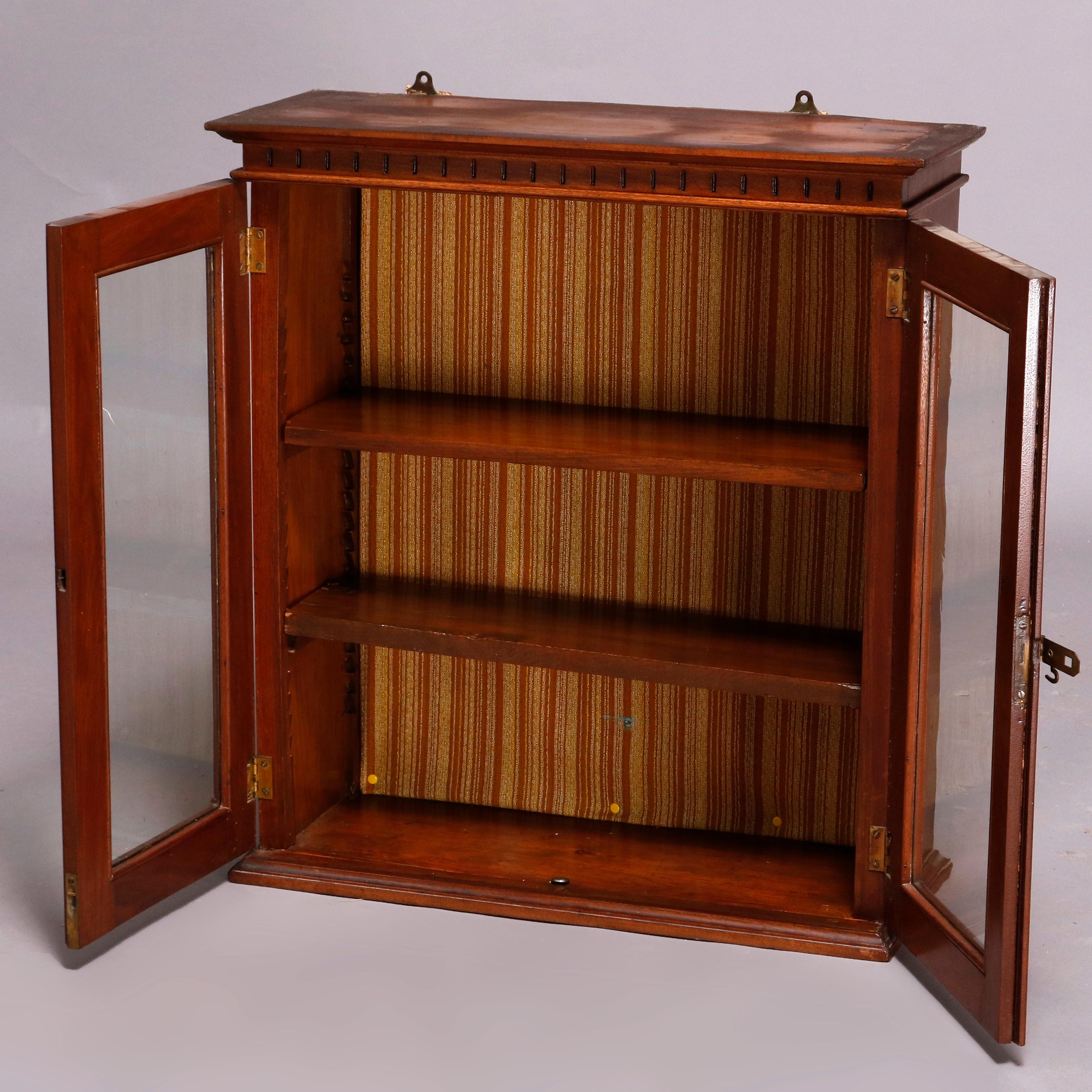 An antique Victorian Eastlake hanging cabinet offers walnut construction with incised decoration and having two glass doors opening to shelved interior, 19th century

***DELIVERY NOTICE – Due to COVID-19 we have employed LIMITED-TO-NO-CONTACT