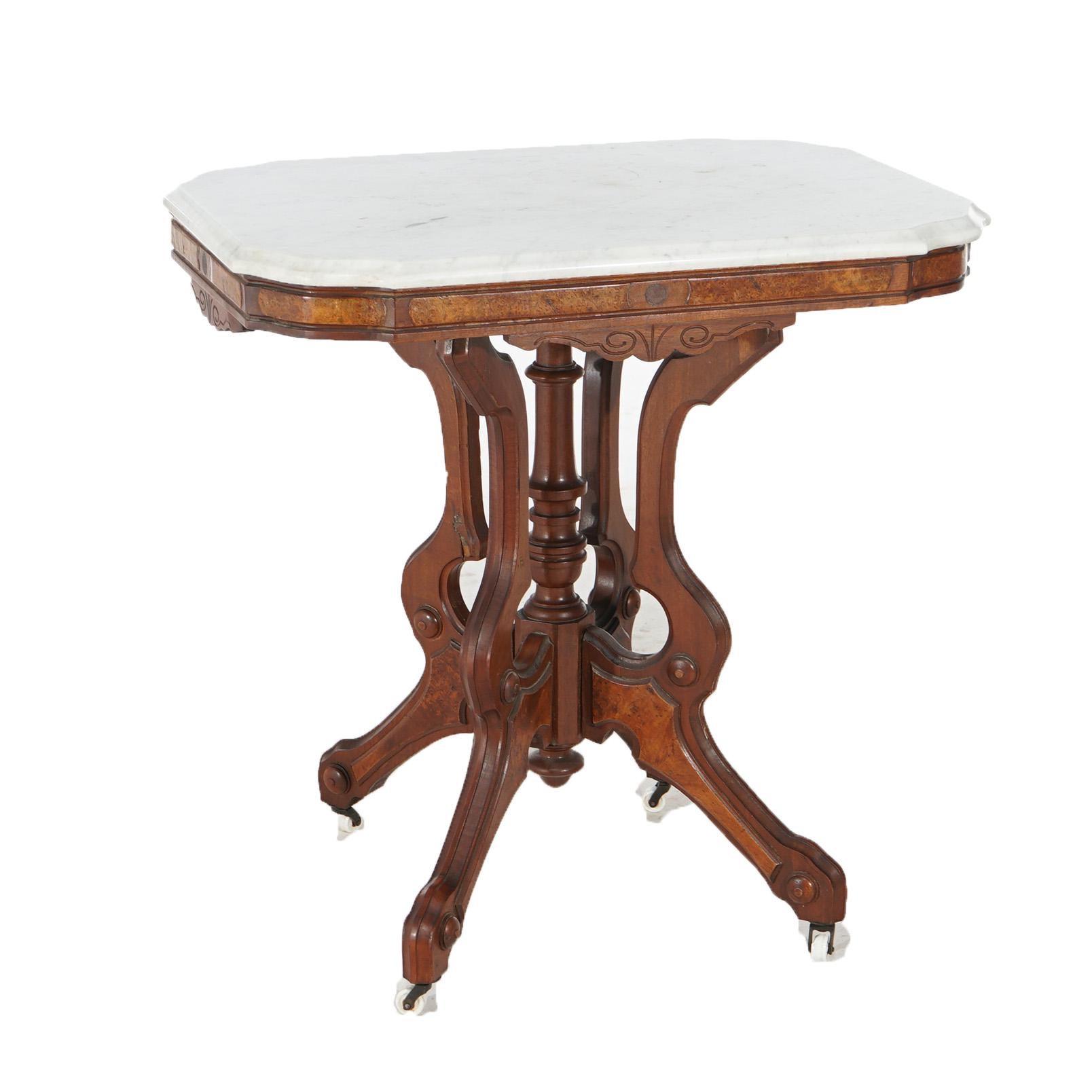 AN antique Eastlake parlor table offers shaped and beveled marble top over walnut base having burl insets, a central turned column and raised on stylized scroll form legs, c1880

Measures - 30.75