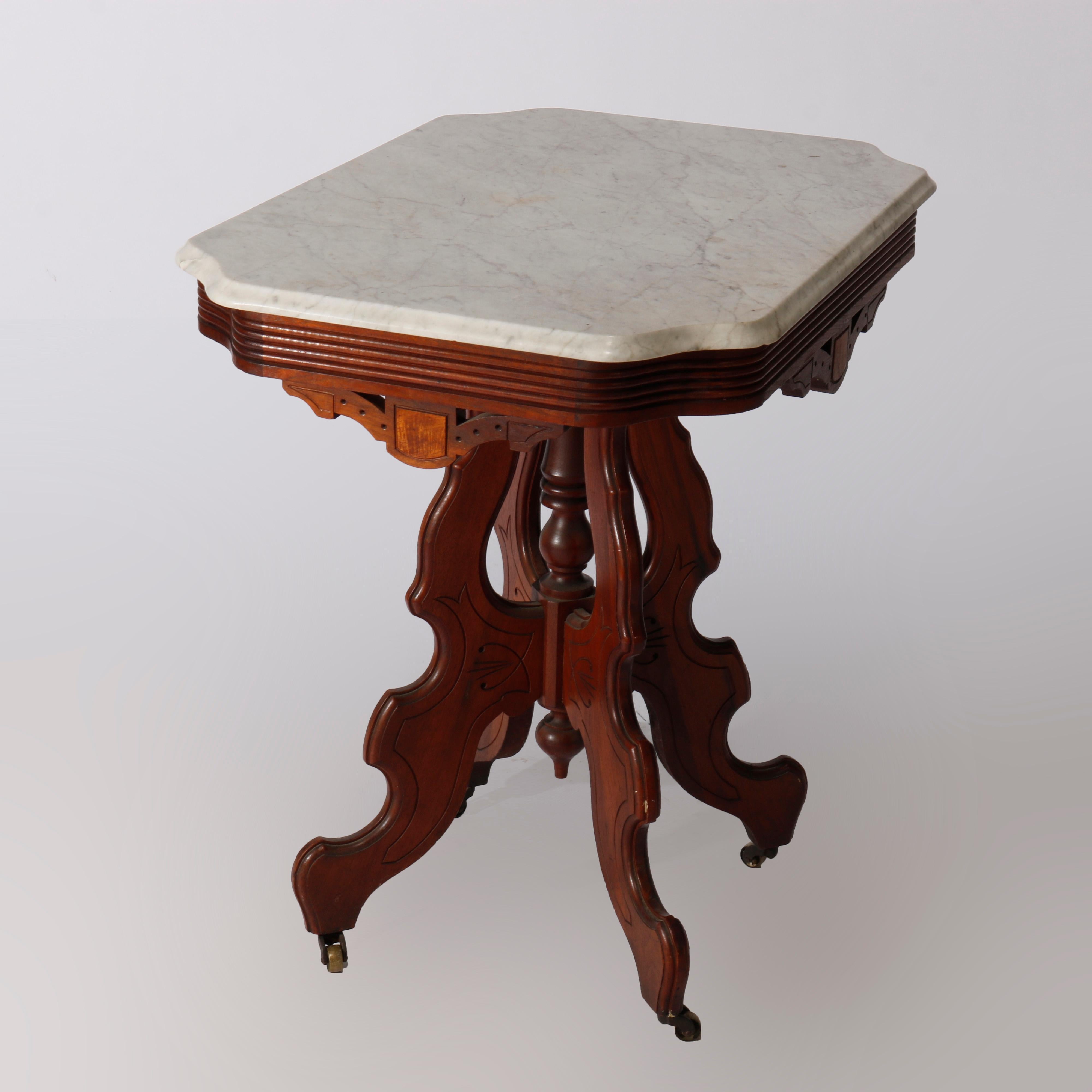An antique Eastlake parlor table offers beveled and stylized clip corner marble top over carved walnut base having burl insets, raised on stylized scroll from legs with central turned column, incised decoration throughout, circa 1890

Measures -