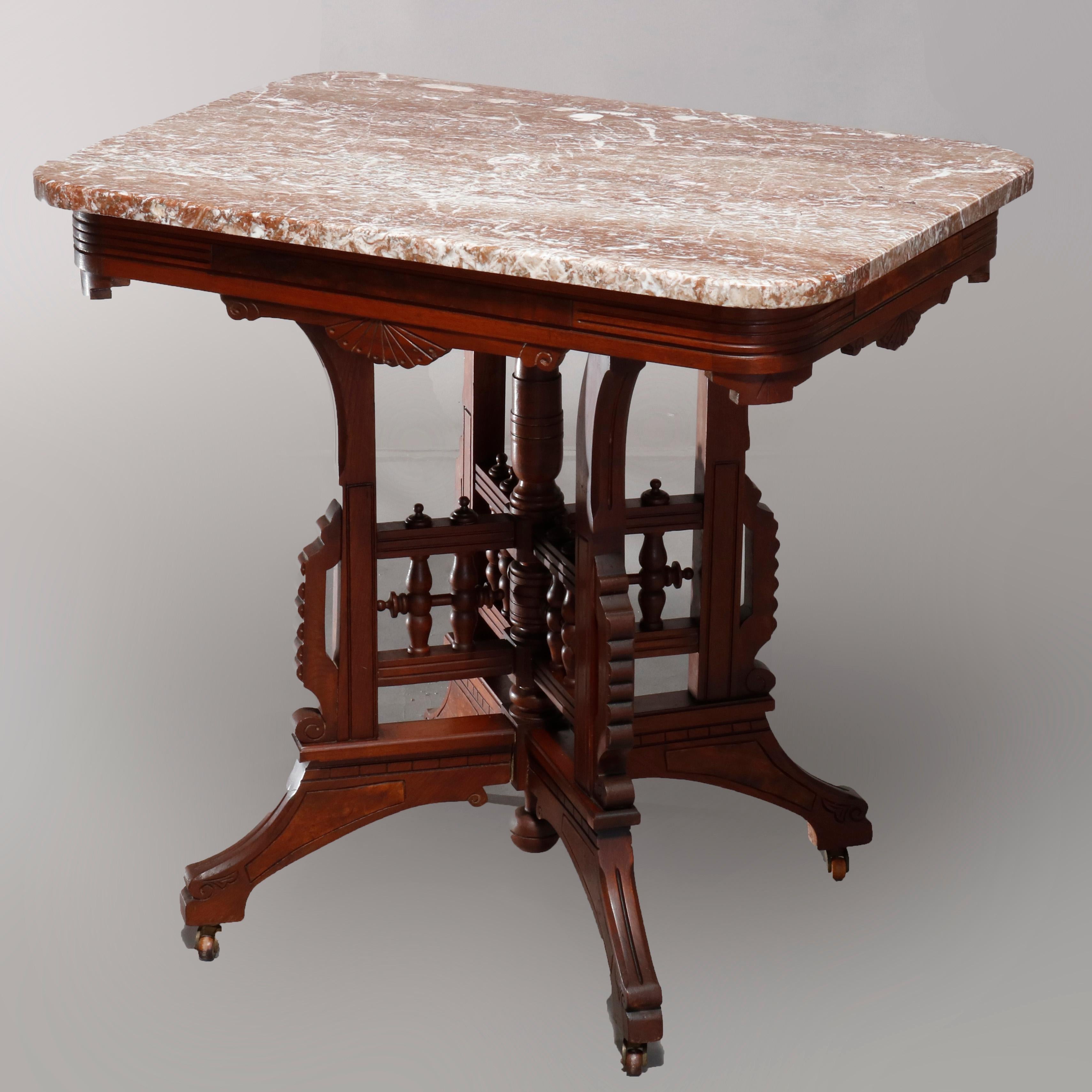An antique Eastlake parlor table offers rectangular form with rouge marble top surmounting carved walnut base having skirt with shell and foliate elements over quadruped stylized stick and ball base, burl insets throughout, circa 1890

Measures:
