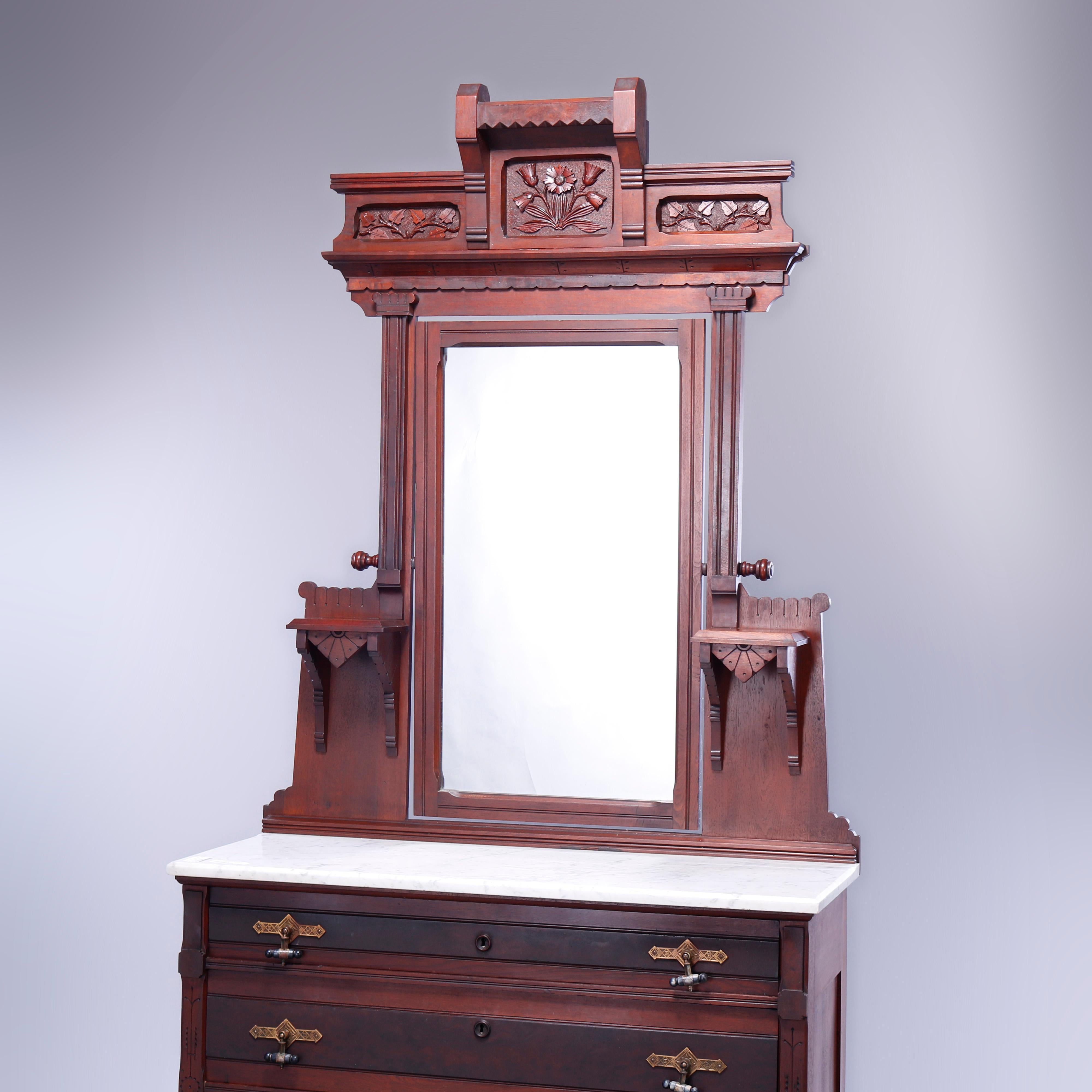 An antique Eastlake dresser offers walnut construction with floral and foliate carved crest over mirror with flanking candle stands surmounting marble top case having three paneled long drawers, incised decoration throughout, c1890

Measures -