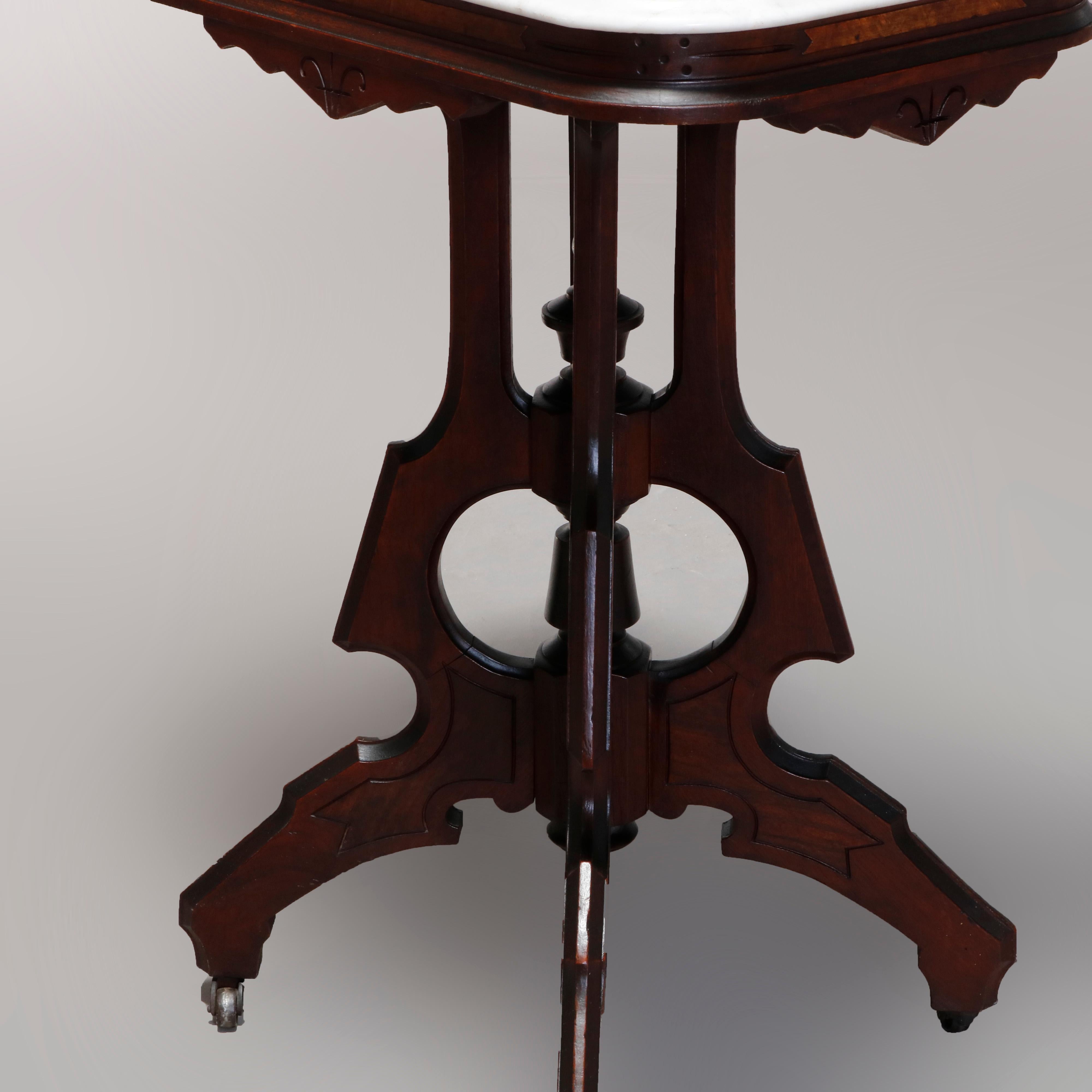 An antique Eastlake side table offers rectangular top surmounting carved walnut base with shaped and scroll incised sh=kirt over four shaped legs surrounding central column with finial and raised on cabriole legs, circa 1890

Measures: 29.75
