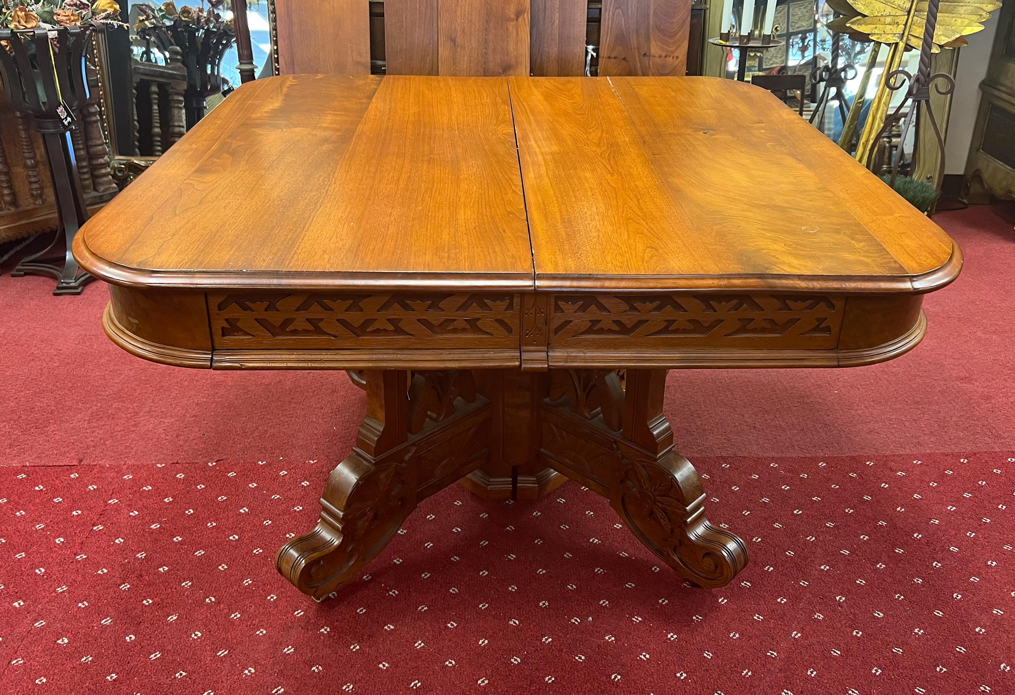 Antique Eastlake dining table. The original wooden glides support the six drop-in leaves that extend the table to 117 inches. The table base, when closed, houses one leg that helps to support the full extension of the table. The table legs feature
