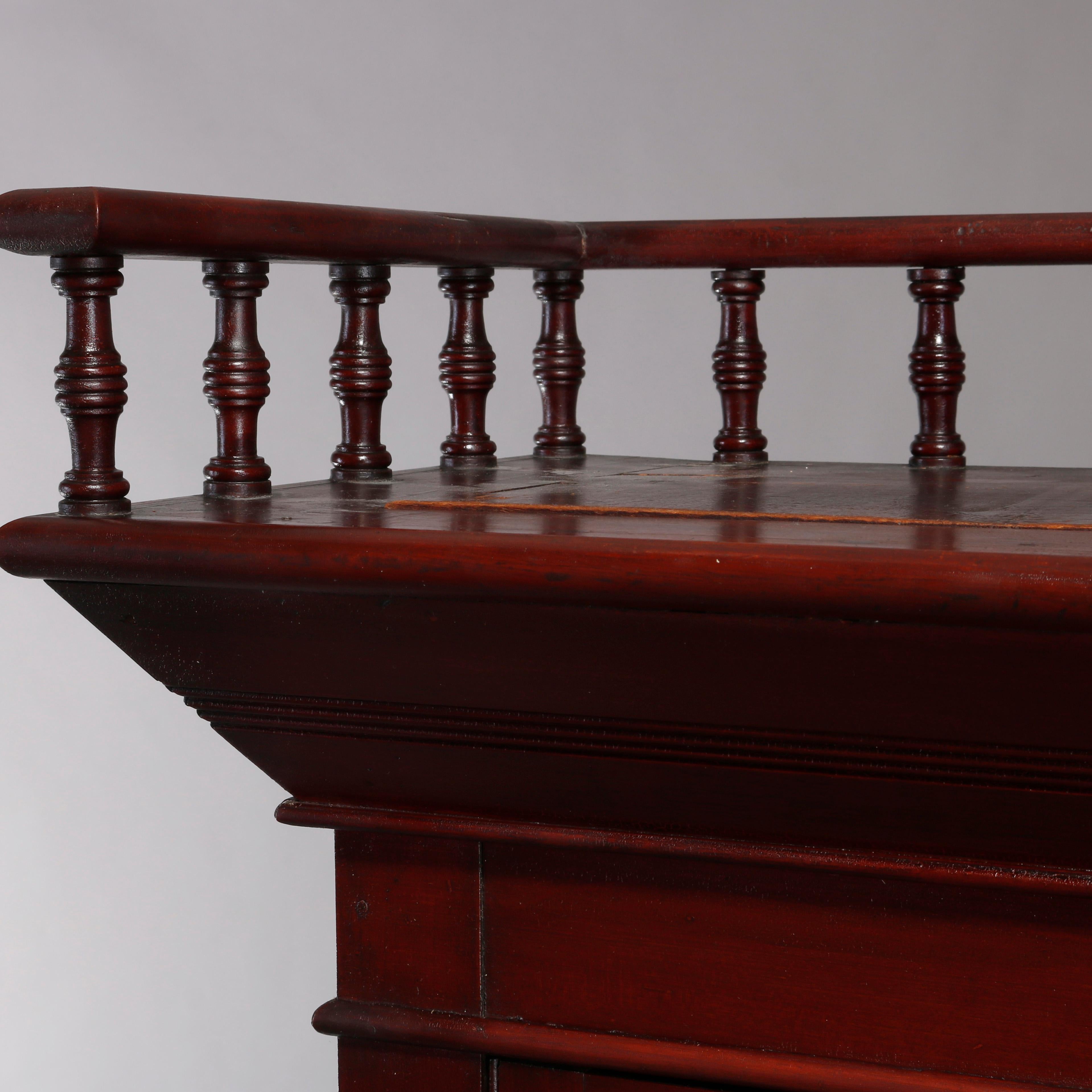 An antique Eastlake bookcase offers mahogany construction with upper gallery having spindled rail surmounting case with double glass doors opening to shelved interior and over double lower drawers, circa 1900

Measures: 70.5