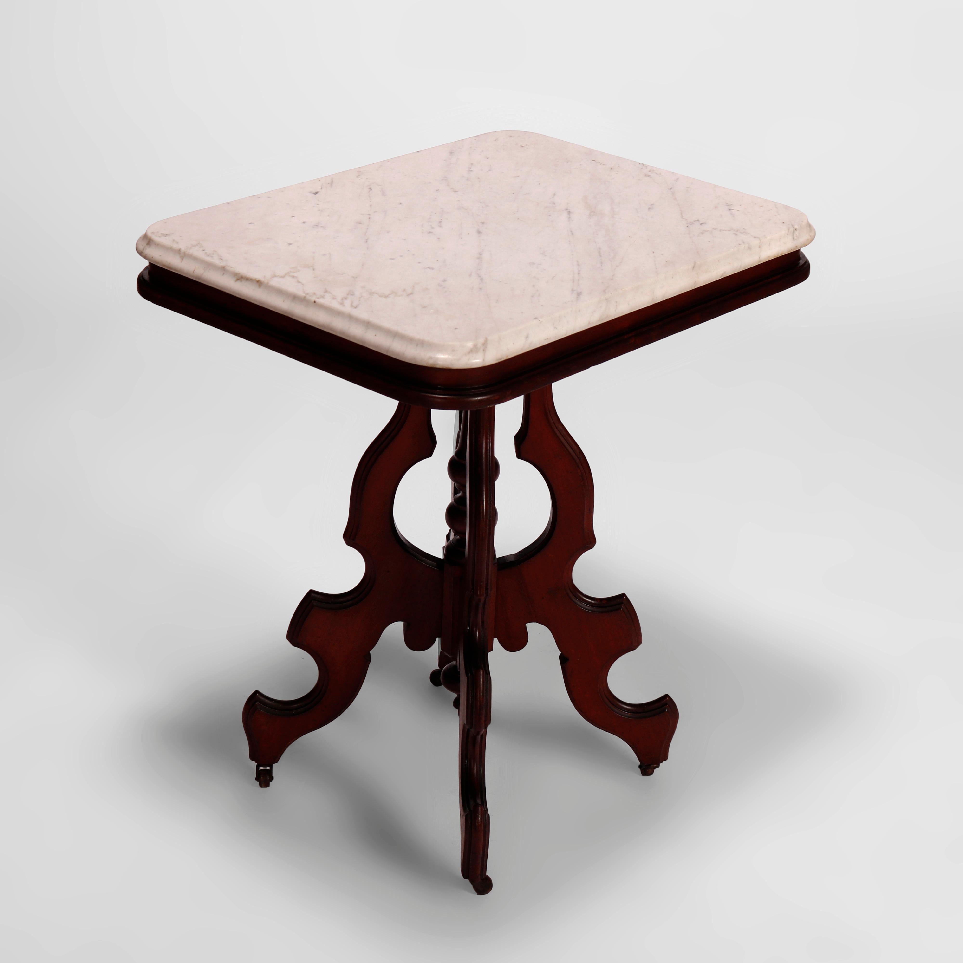 Une table de salon antique Eastlake offre un plateau en marbre biseauté sur une base en noyer avec quatre supports façonnés et une colonne centrale tournée, le tout reposant sur des pieds cabriole stylisés, vers 1890

Mesures- 29''H x 26.25''W x
