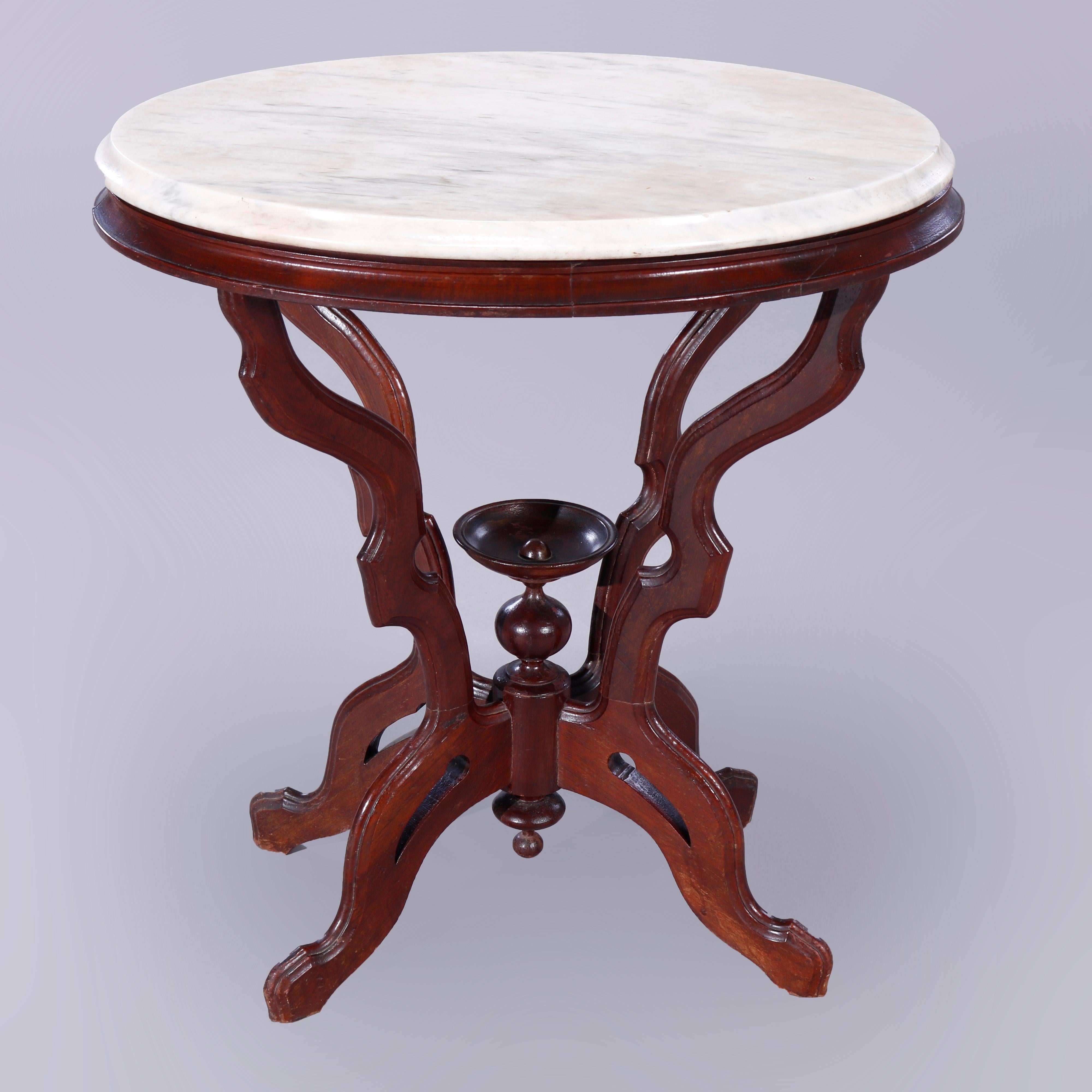 An antique Eastlake parlor table offers beveled marble top in oval form over carved walnut base having stylized scroll form legs with central urn finial and lower drop finial, c1890

Measures - 28''H x 26.25''W x 19''D.

Catalogue Note: Ask about