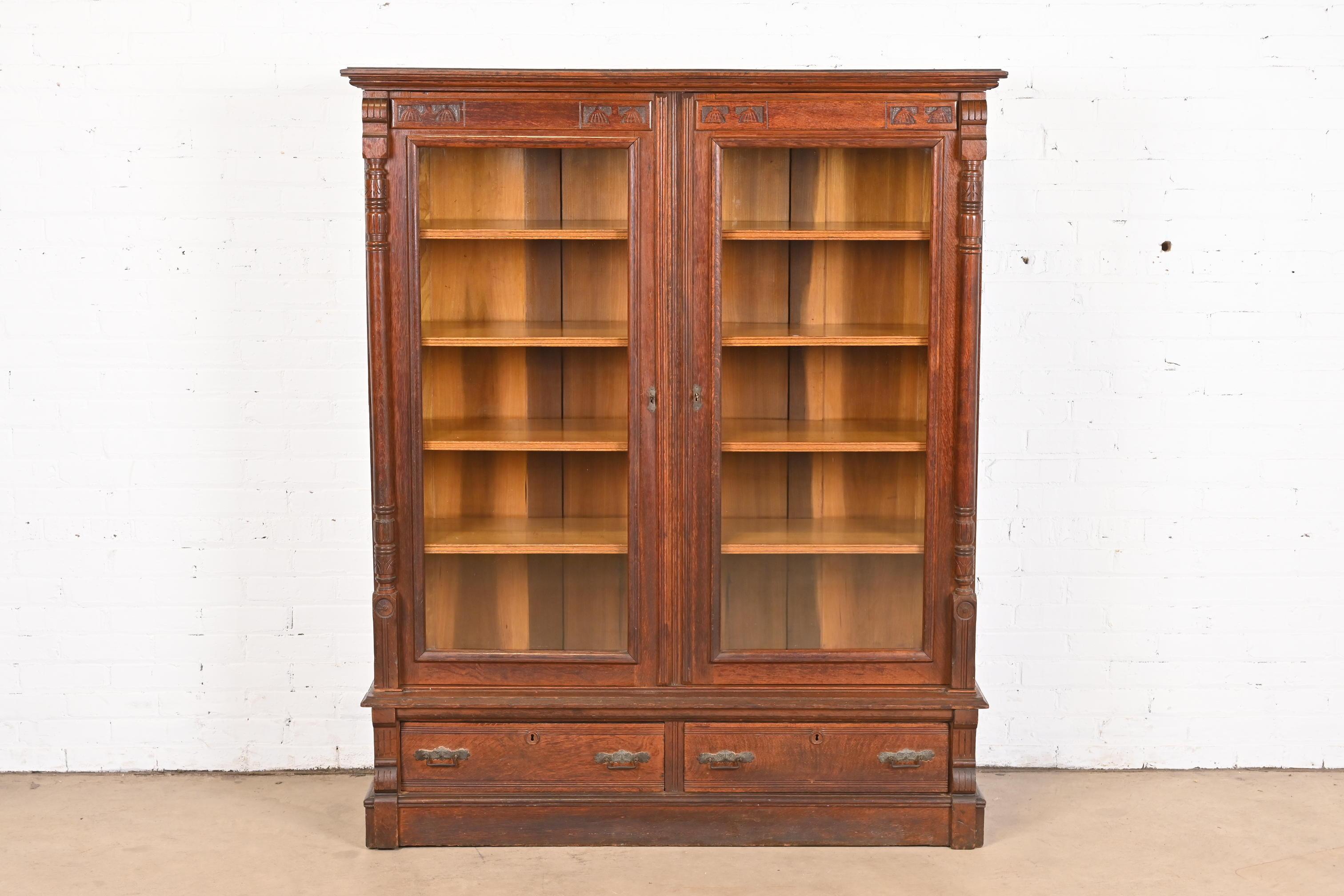 An outstanding antique Eastlake Victorian bookcase cabinet

In the manner of Herter Brothers

USA, Circa 1880s

Carved solid quarter sawn oak, with glass front doors and brass hardware.

Measures: 53.25