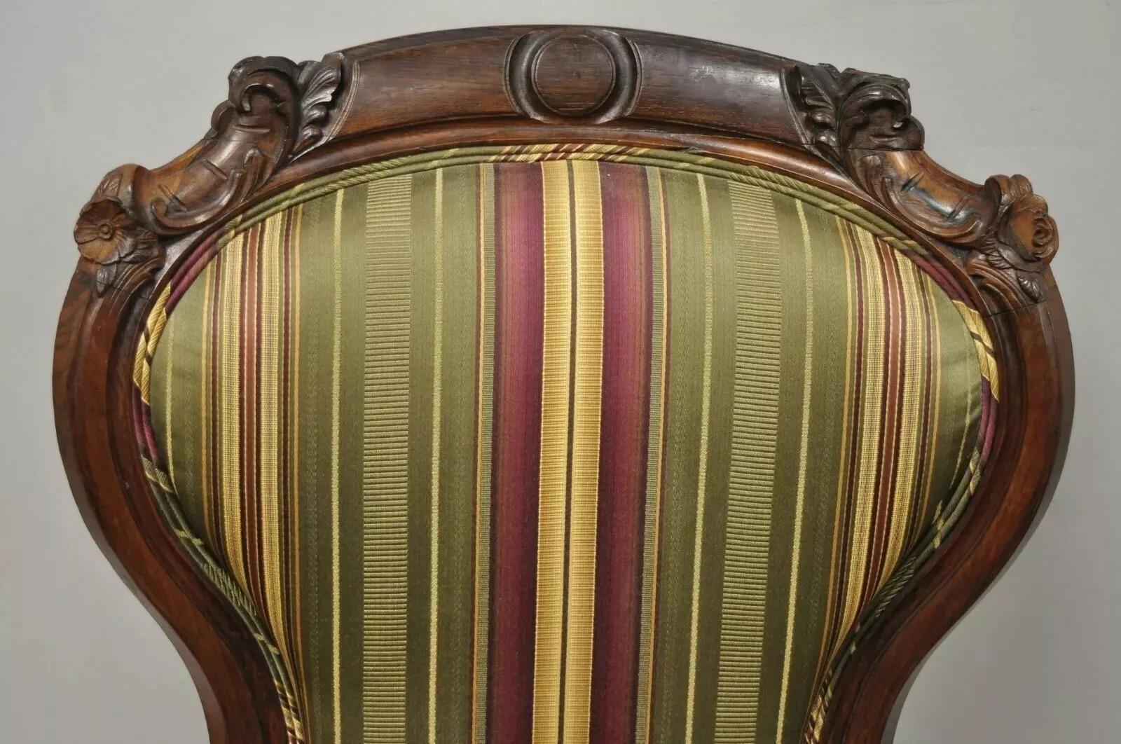 Antique Eastlake Victorian Carved Rosewood Parlor Balloon Back Arm Chair. Item features beautiful wood grain, upholstered armrests, very nice antique item. Circa 19th Century. Measurements: 40