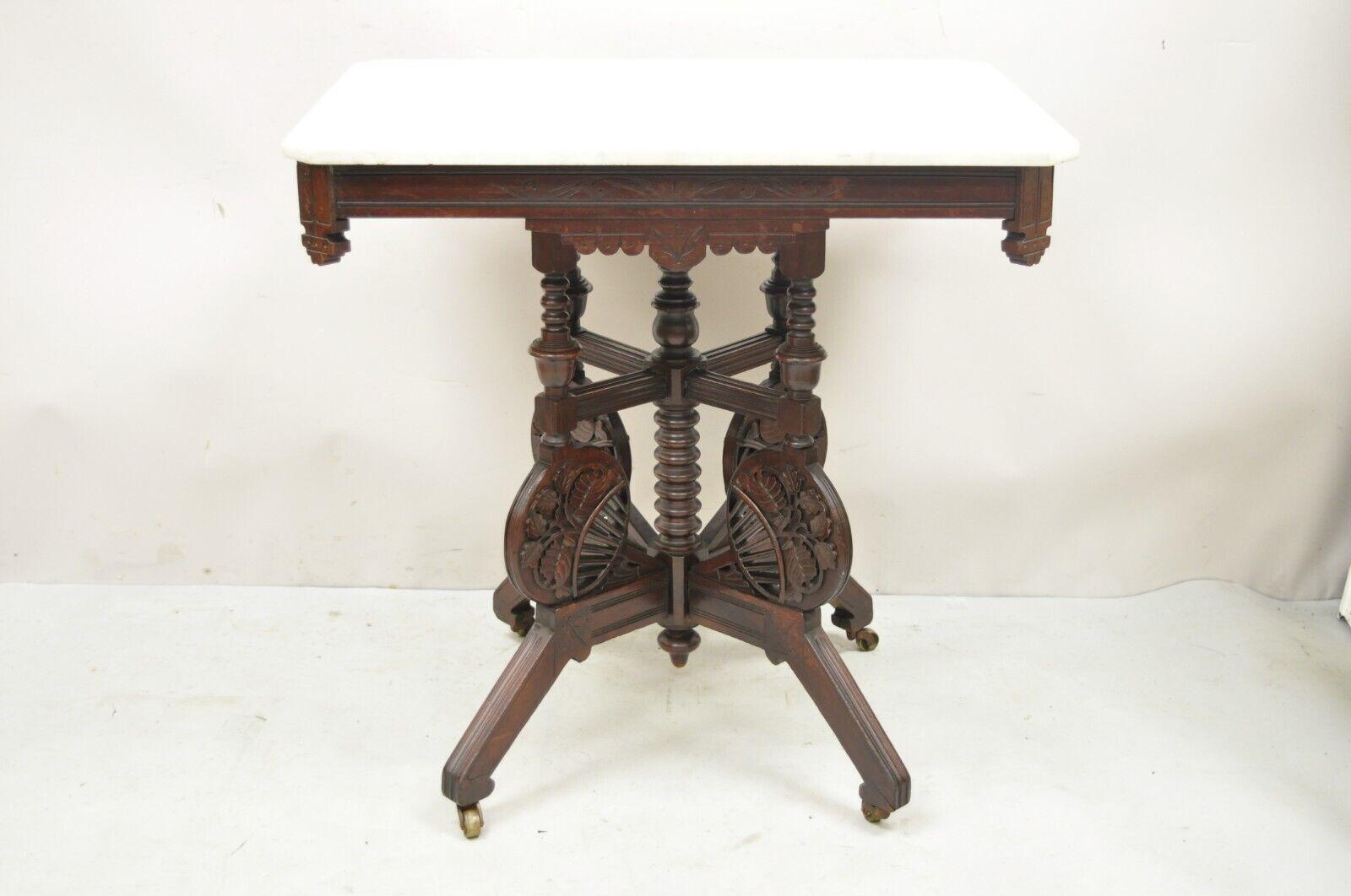 Antique Eastlake Victorian floral carved walnut parlor side table w/ marble top. Item features an ornately carved base with flowers and turn carved spool accents, rolling casters, marble top, very nice antique item, quality craftsmanship. Circa Late
