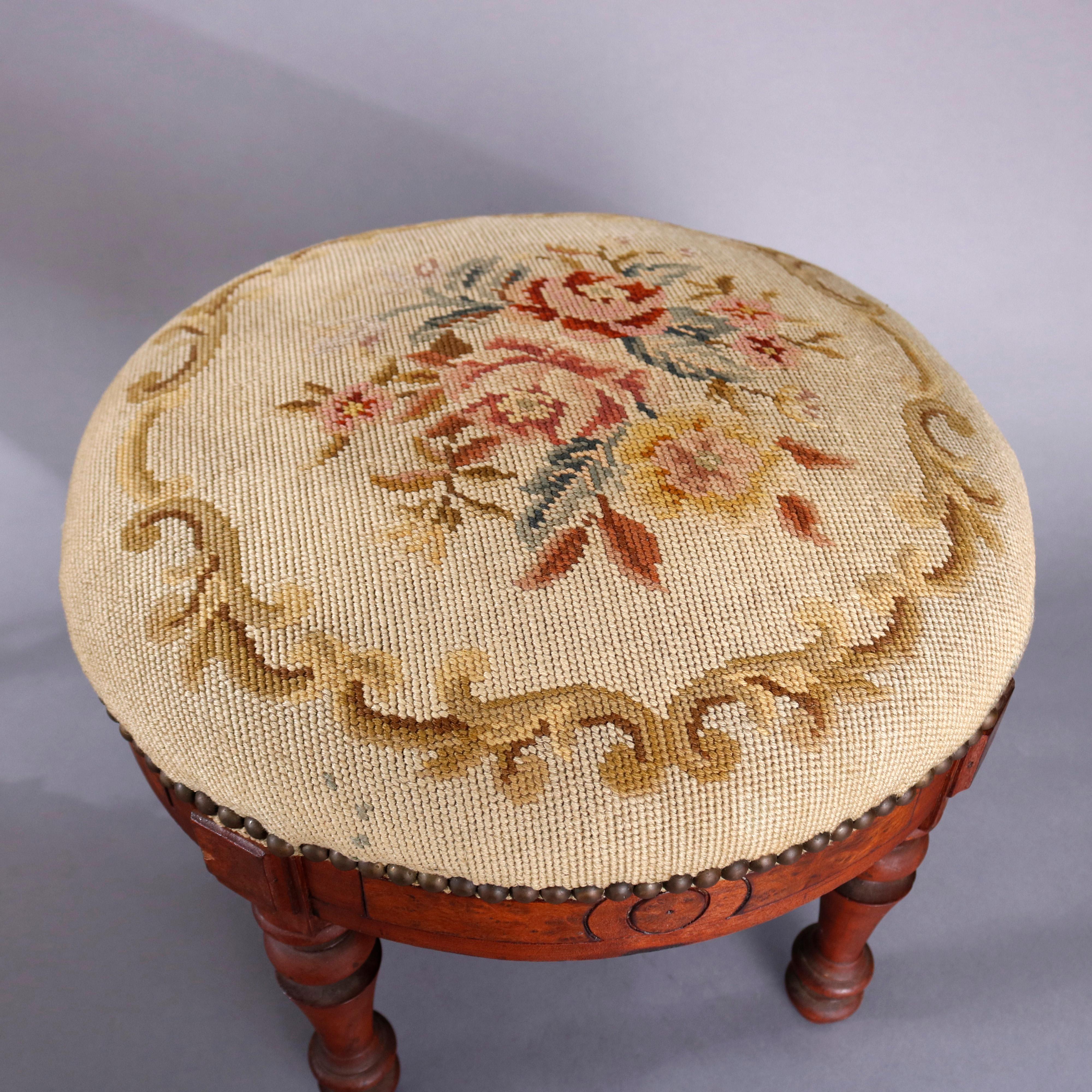 An antique Eastlake footstool offers found form with floral needlepoint seat surmounting carved walnut base with burl panels and raised on turned legs, circa 1890

Measures- 15.5