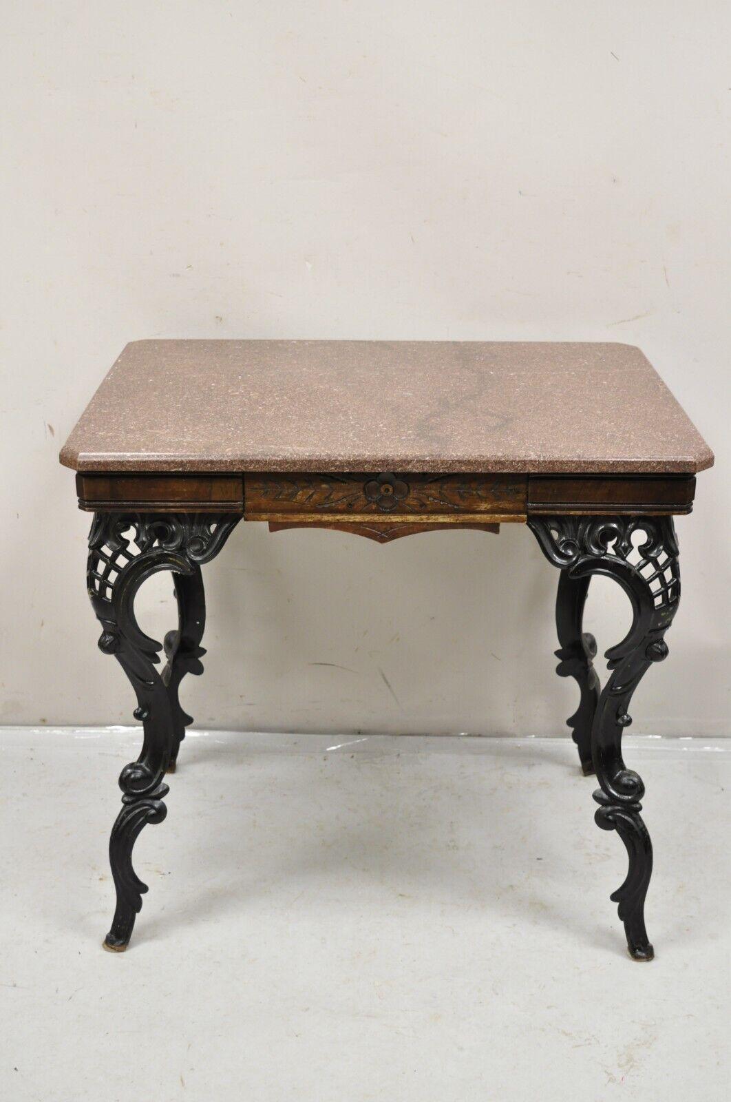 Antique Eastlake Victorian Marble Top Walnut Table with Cast Iron Legs. Item features a unique black cast iron pierced carved cabriole legs, marble top, carved walnut skirt, very nice antique item. Circa 19th Century. Measurements: 28