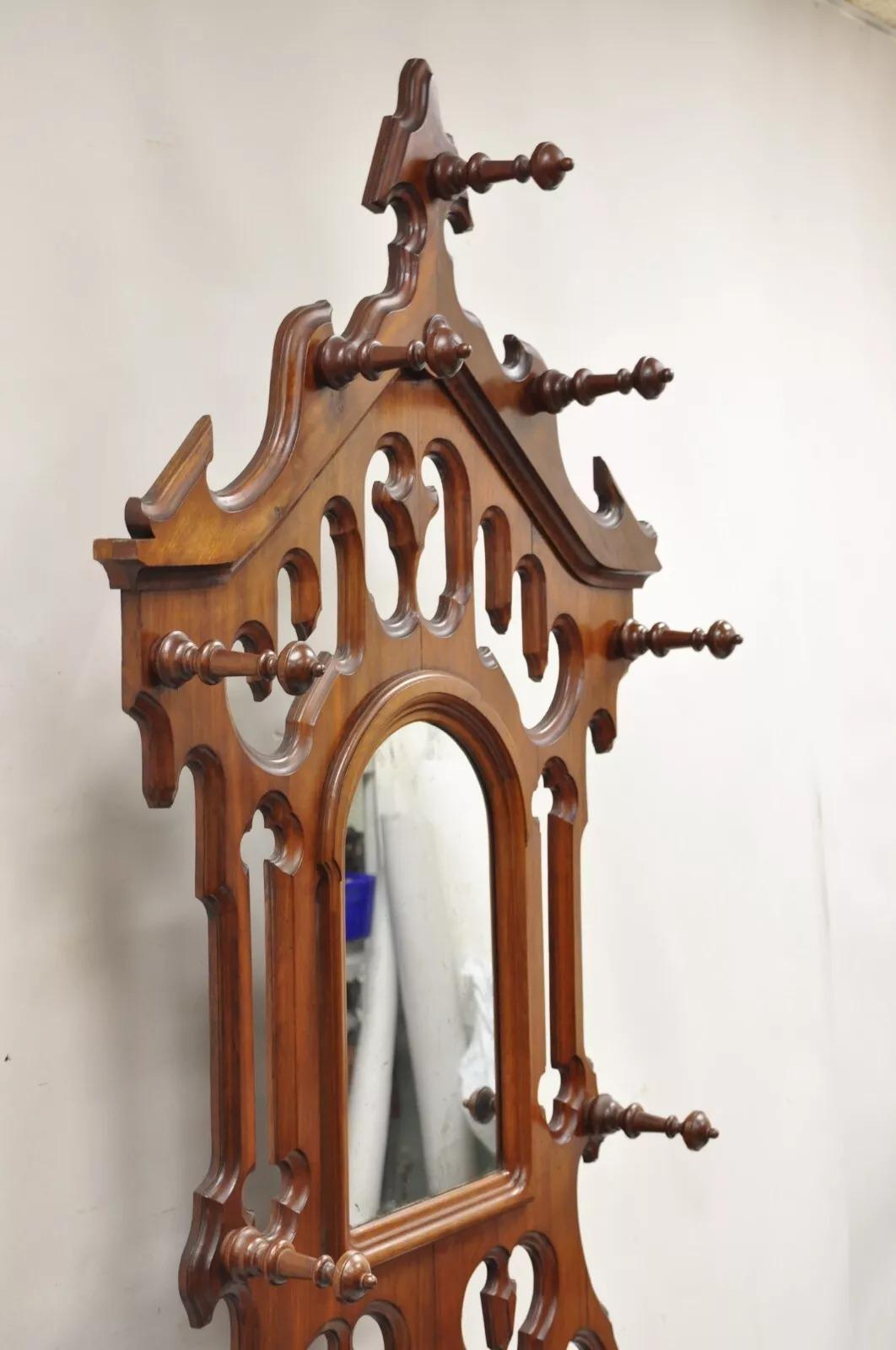 Antique Eastlake Victorian Walnut Coat Hall Tree Umbrella Stand with Mirror and Cast Iron Shell Form Drip Pan. Appears to have been professionally refinished at some point over the years. Circa Late 19th Century. Measurements: 89.5