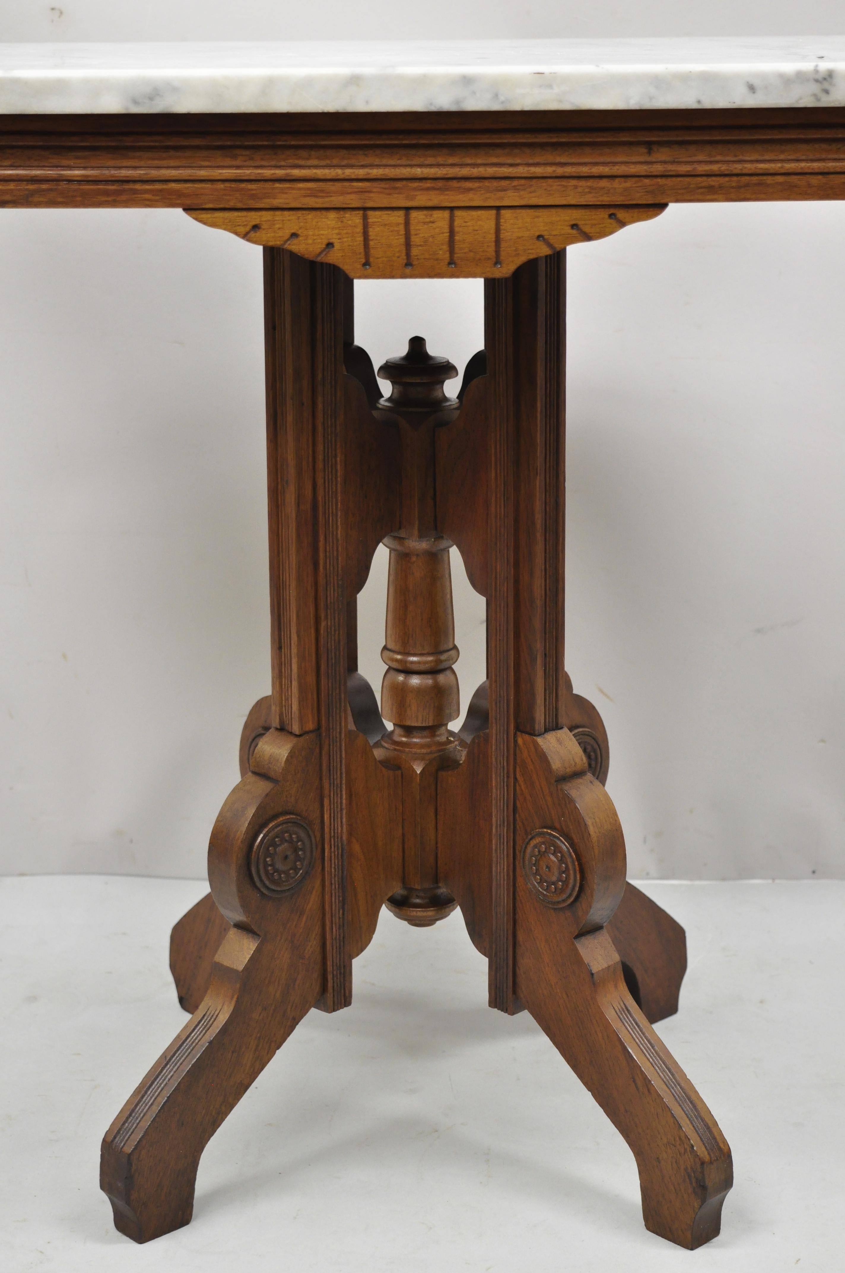 Antique Eastlake Victorian walnut marble top parlor lamp side table. Item features carved walnut pedestal base, marble top, very nice antique item, great style and form. Circa 1900s. Measurements: 28