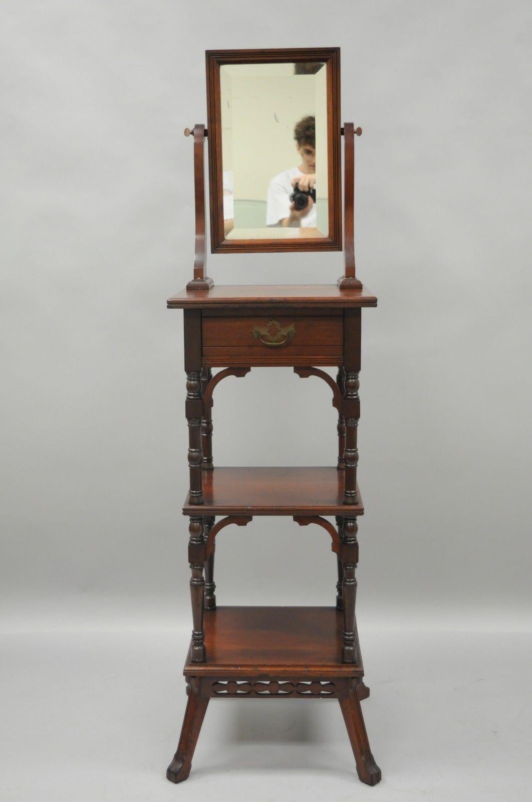Antique Eastlake Victorian shaving stand and mirror. Item features solid walnut construction, bevelled glass mirror, single knapp joined drawer, two lower shelves, ornate brass handle, quality American craftsmanship, circa mid-late 1800s.