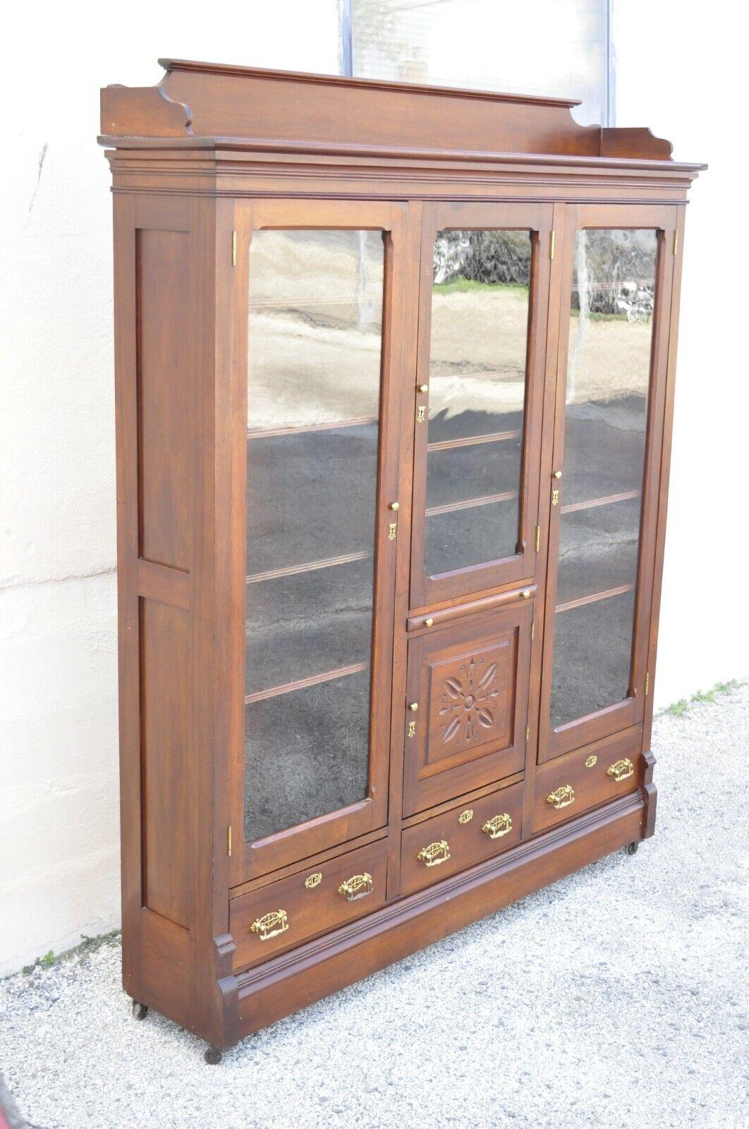 Antique Eastlake Victorian Walnut Wavy Glass Triple Bookcase Display Cabinet In Good Condition For Sale In Philadelphia, PA