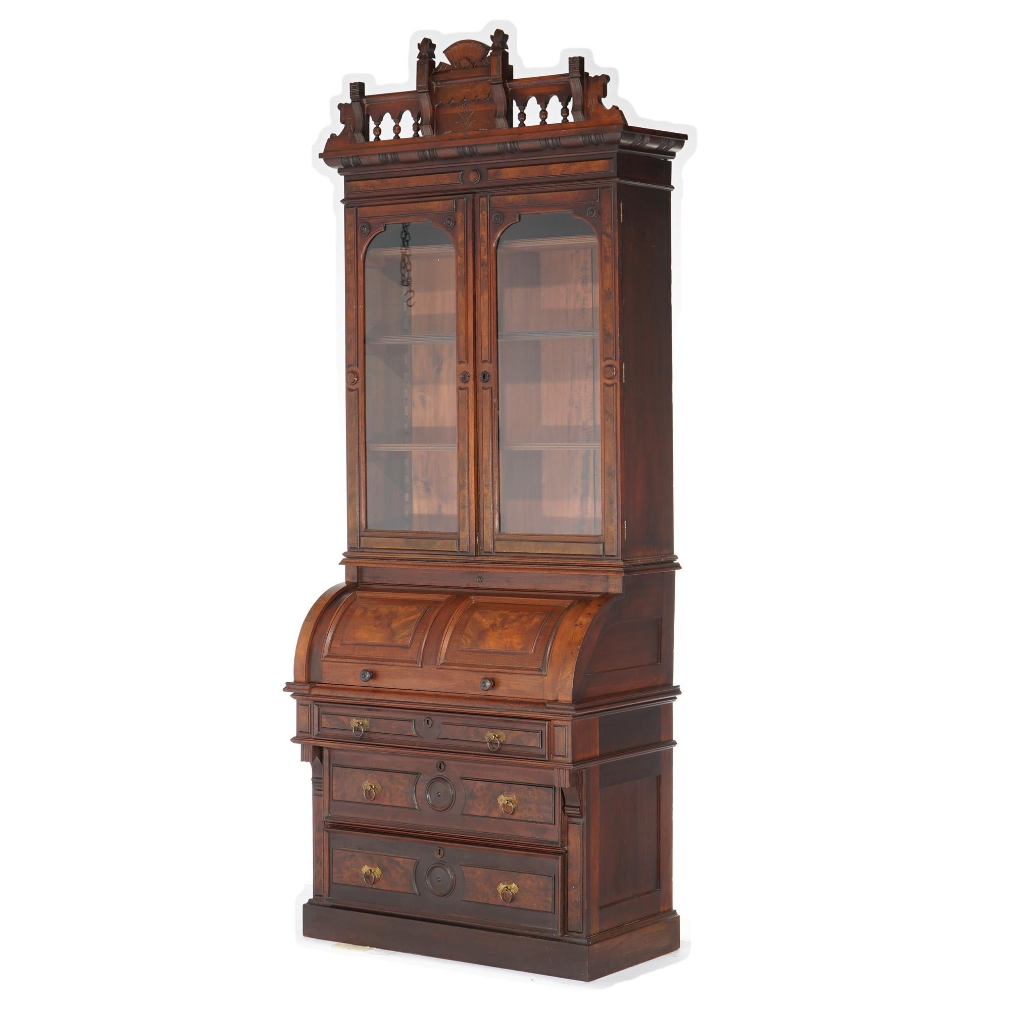 An antique Eastlake secretary offers walnut and burl construction with upper having double glass door bookcase over barrel roll desk with lower long drawers, incised decoration throughout, c1880

Measures- 99.5''H x 38.25''W x 21.25''D

Catalogue
