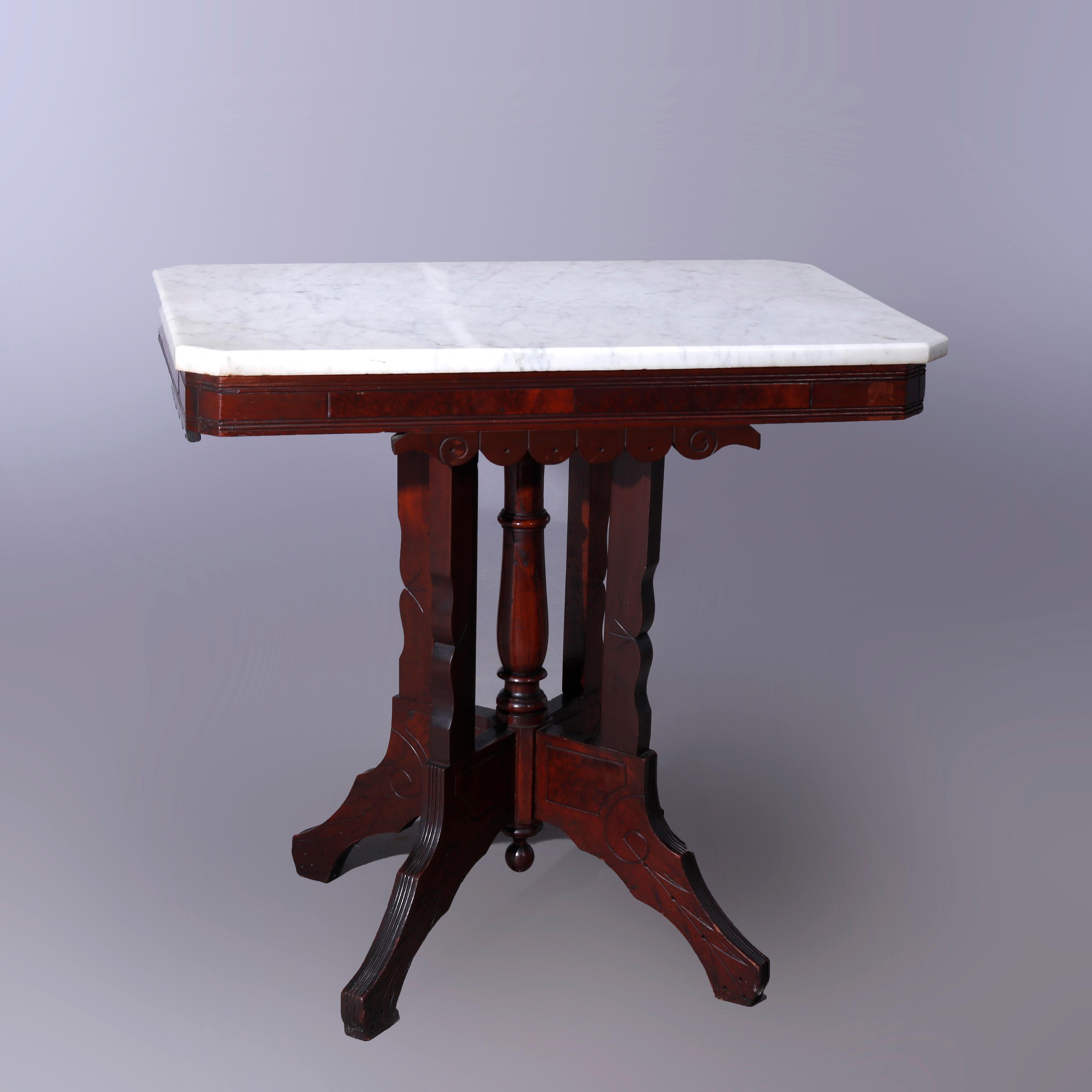 Ein antiker Eastlake Salontisch bietet eine rechteckige Platte mit Clip-Ecke auf einem Nussbaumsockel mit eingeschnittener Dekoration und Wurzelholzeinsätzen, der auf geformten Beinen mit einer zentralen gedrehten Säule steht, um 1890

Maße -