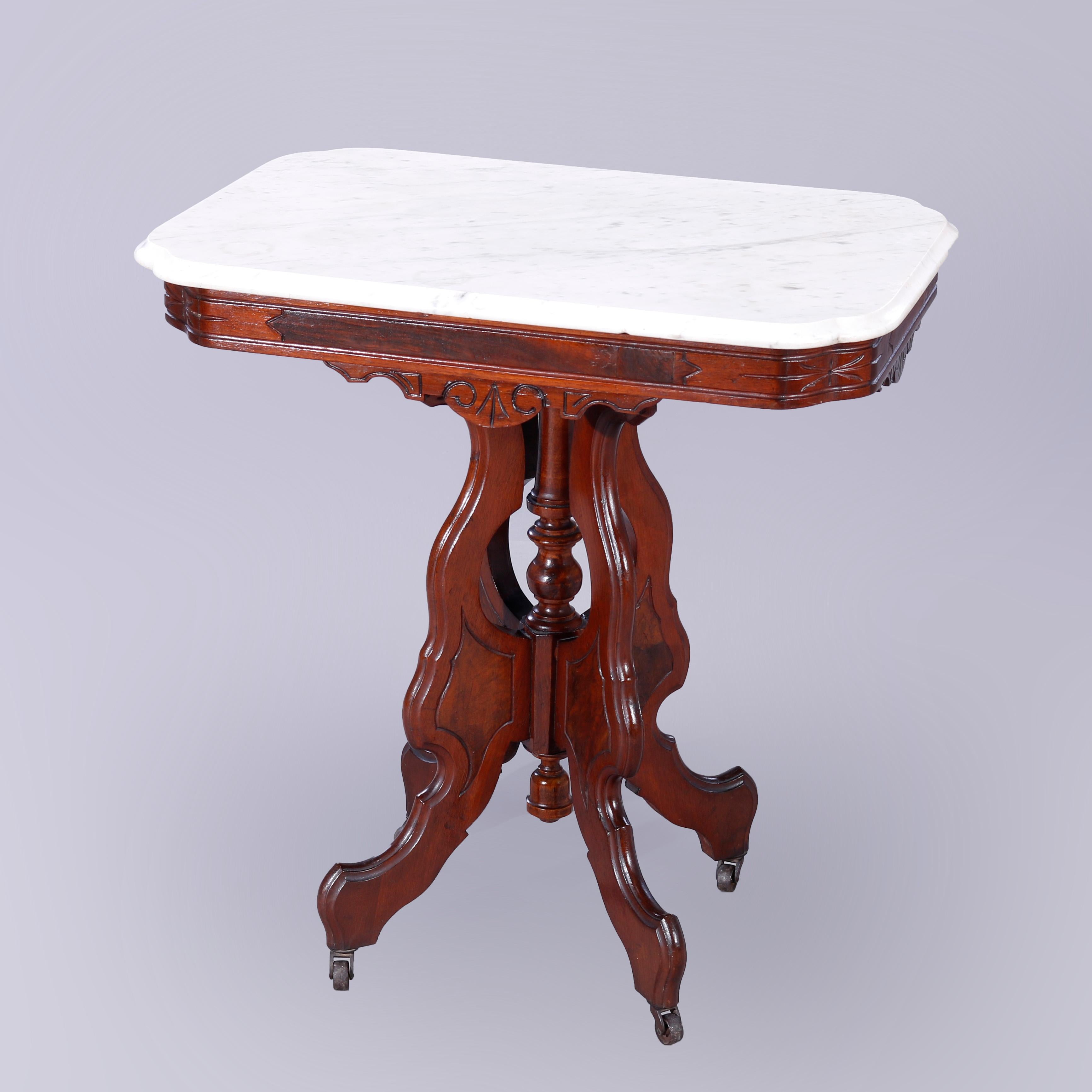 An antique Eastlake parlor table offers beveled stylized clip-corner rectangular top over carved and incised walnut base with inset burl panels and raised on stylized scroll form legs with central turned column and drop finial, c1890

Measures -