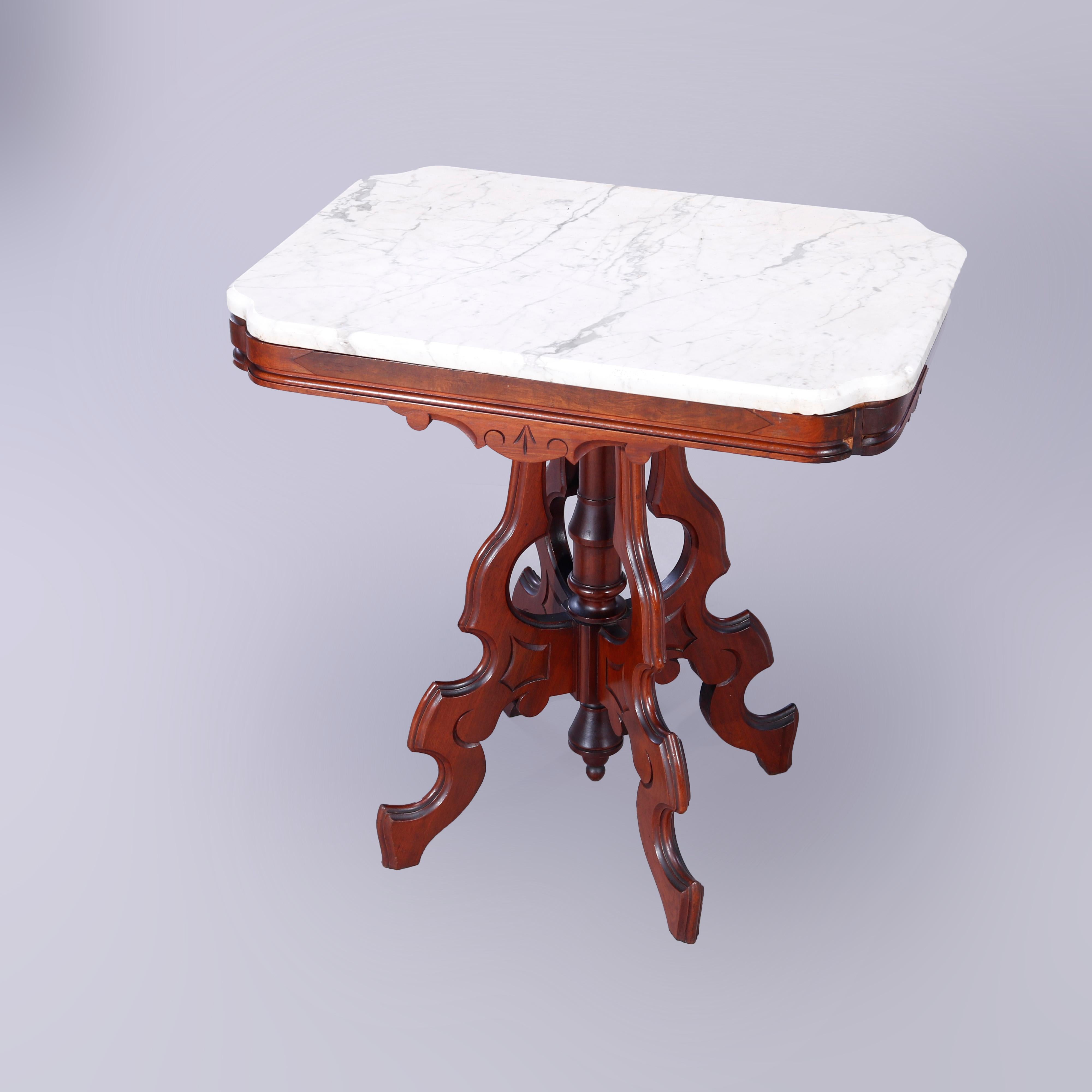 An antique Eastlake parlor table offers beveled & clip-corner rectangular marble top over carved walnut base with burl insets and incised decoration, raised on stylized scroll form legs having central turned column and drop finial, c1890 

Measures