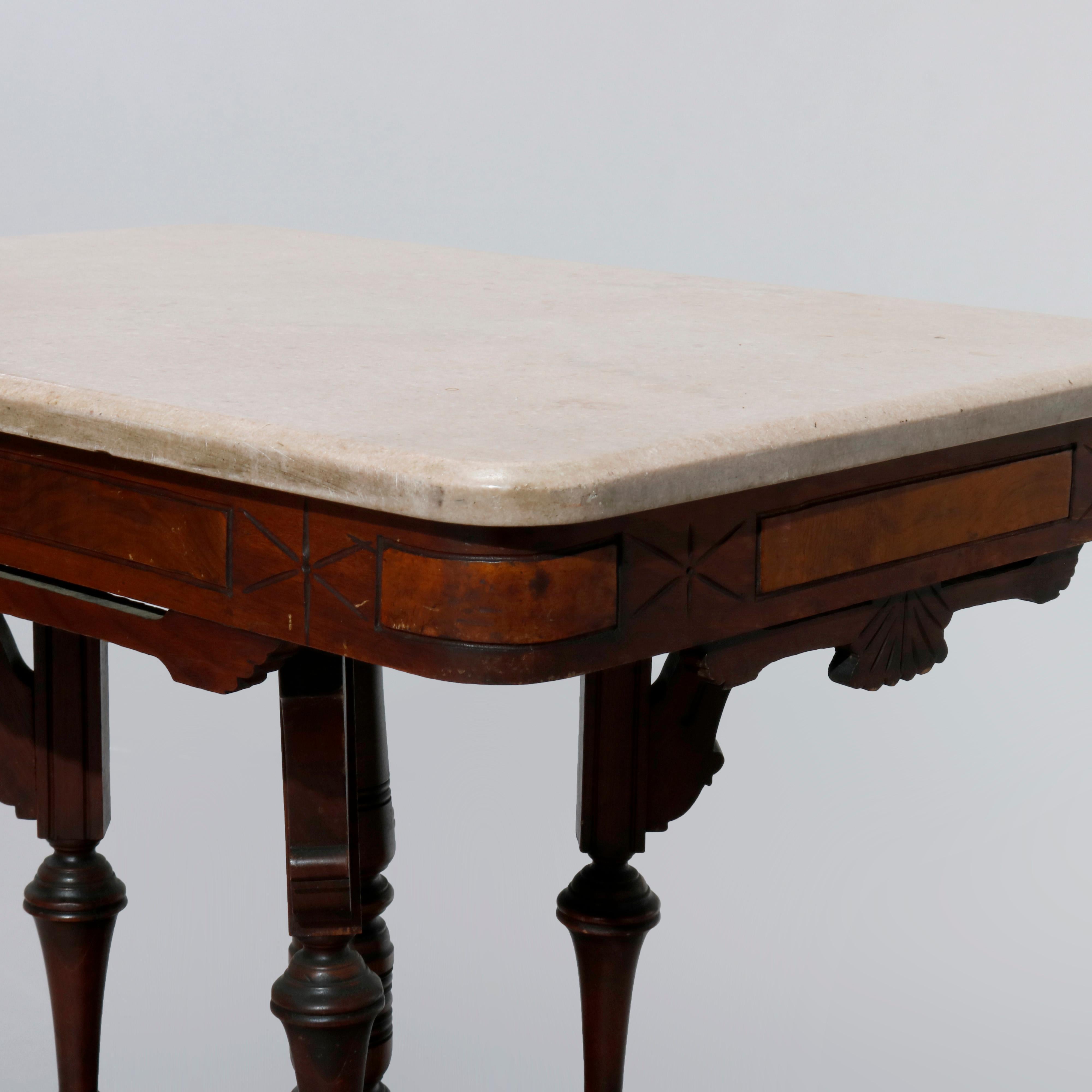 An antique Eastlake parlor table offers marble top over carved walnut base having burl insets, turned supports and pierced foliate corbels, c1890

Measures: 29