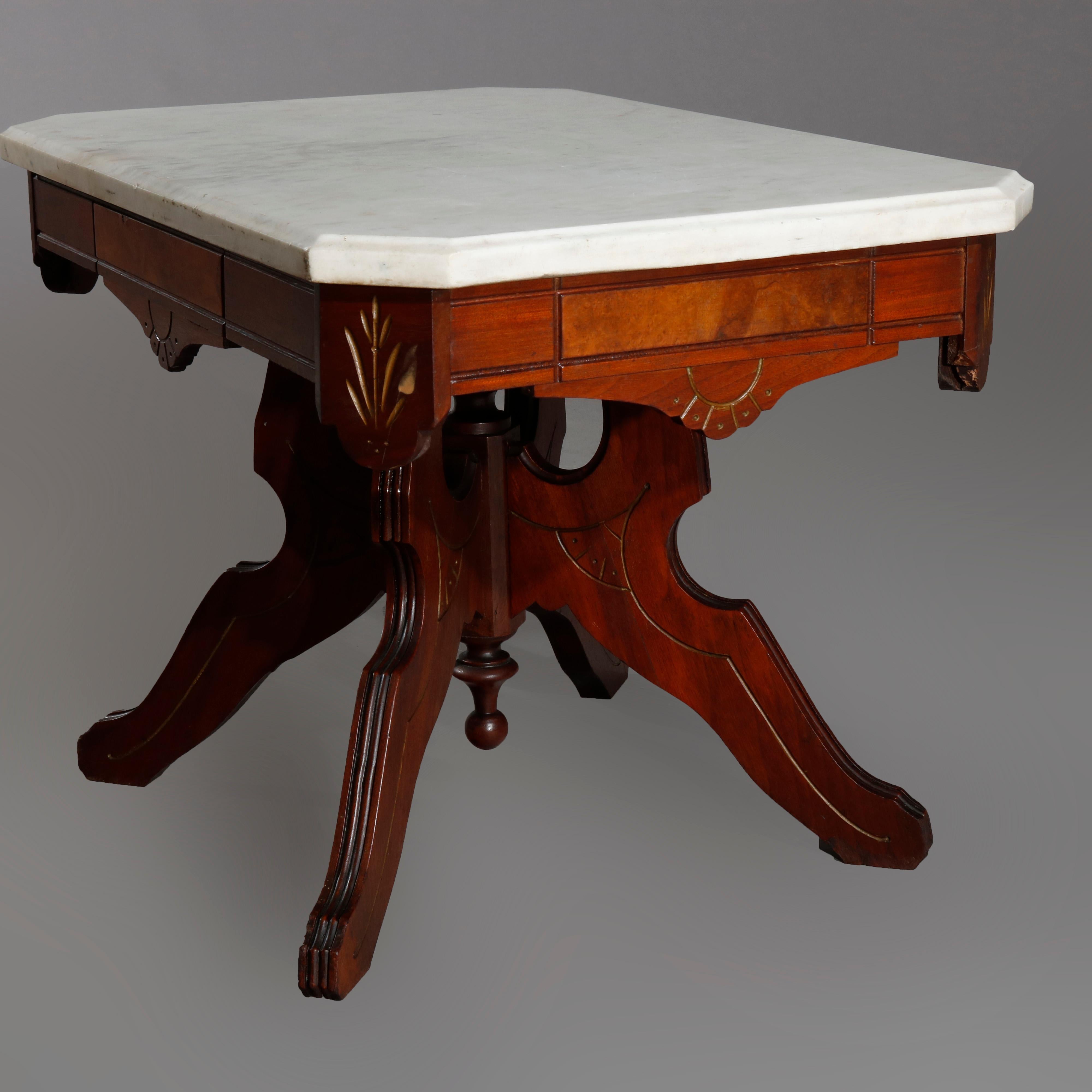 An antique Eastlake low center table offers beveled clip corner top surmounting walnut base with carved shaped skirt having burl insets and incised sunburst raised on shaped legs with central drop finial, circa 1890

Measures: 18.5