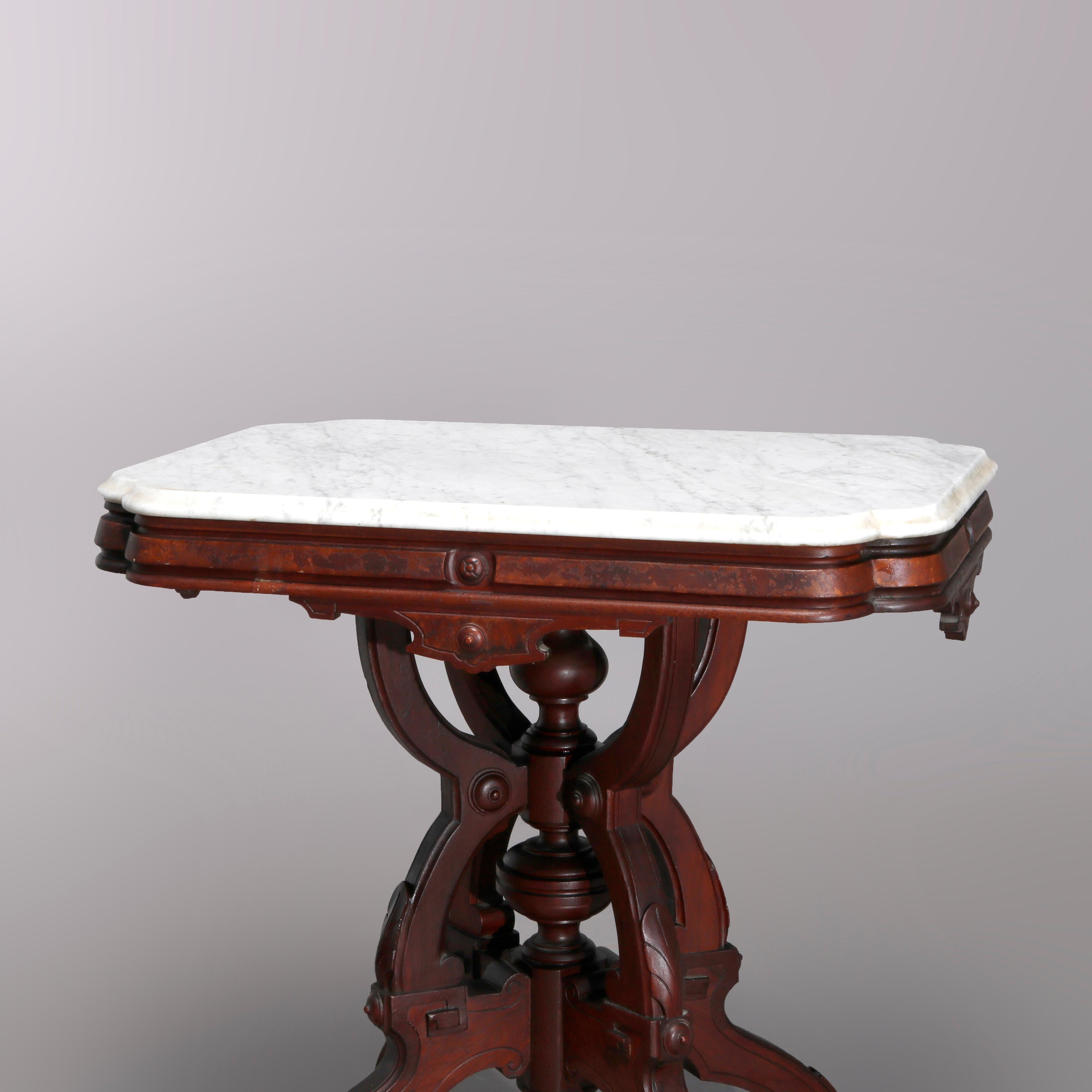 An antique Eastlake center table offers shaped beveled marble top surmounting carved walnut and burl base raised on shaped legs with central turned column, c1890.

Measures: 30.25