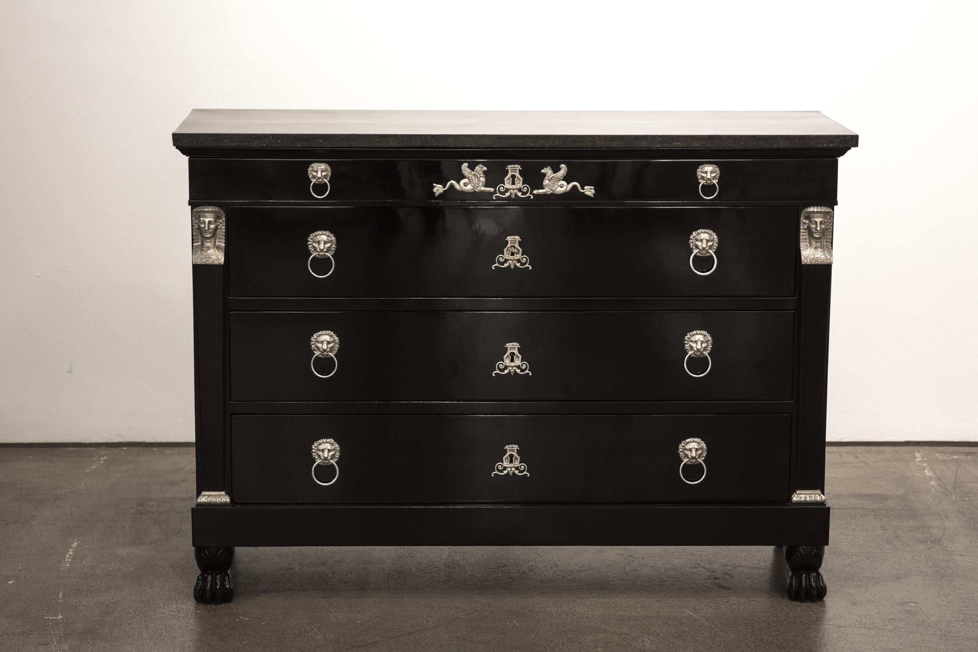 An original antique Empire chest of drawers from the early 19th century from France.
The corpus of the commode is made from oak and is ebonized and polished.

The commode has four drawers and an original marble top. On both sides it is flanked by