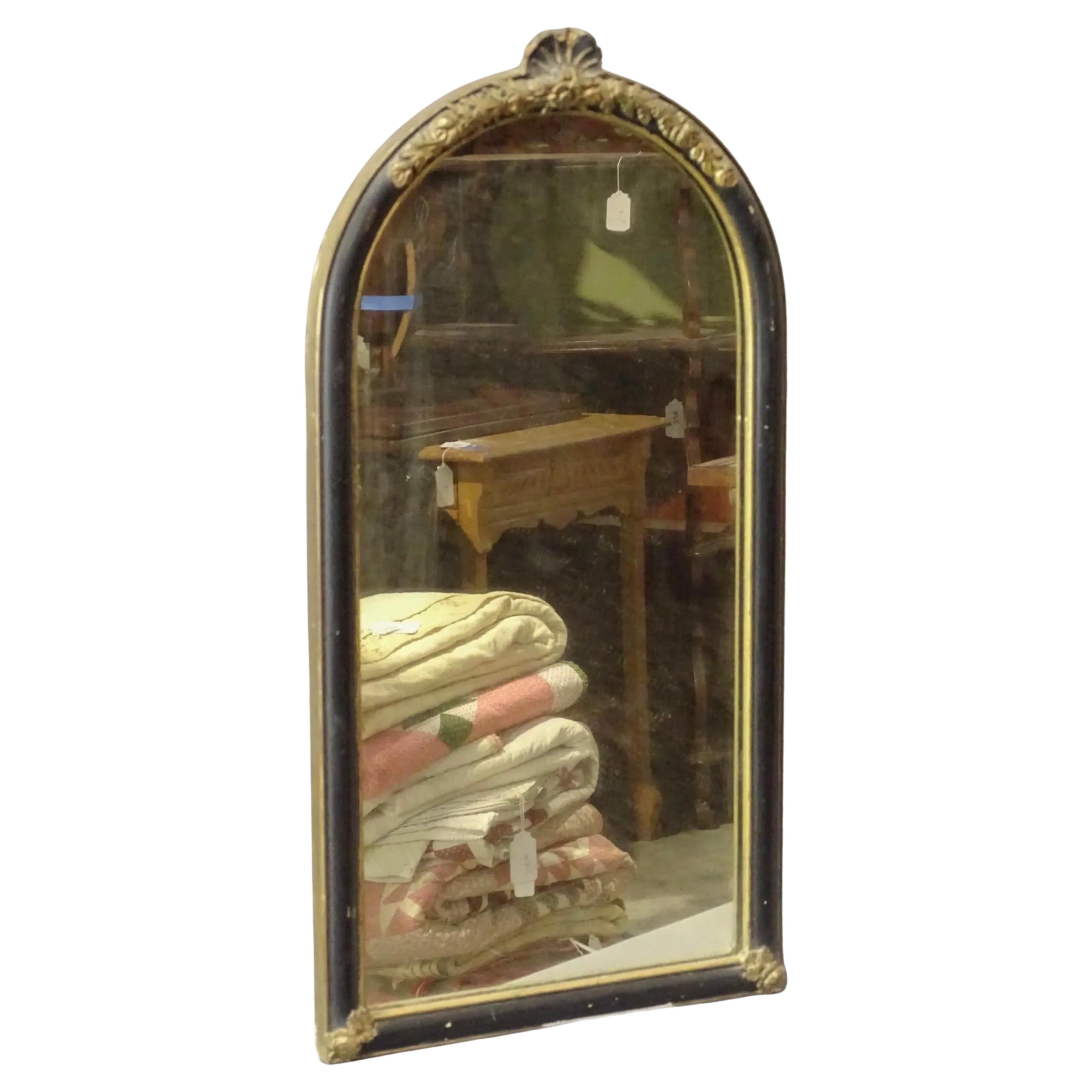 A small continental Queen Anne style mirror with ebonized frame, gold gilt shell decoration on the oval top and gold trim accent that surrounds the frame.
This smaller size mirror lends itself for a powder room mirror, vanity mirror or any where a