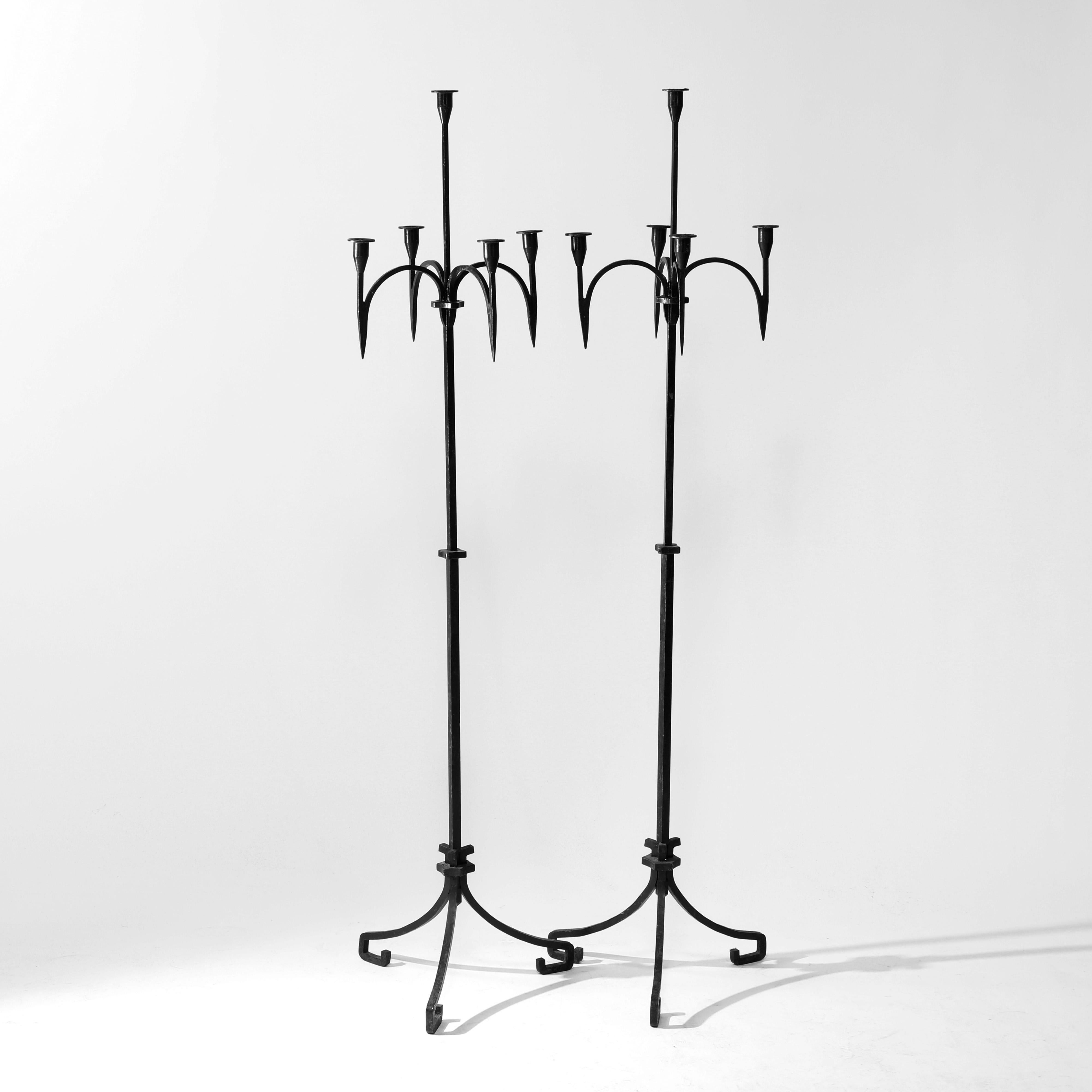 An antique pair of floor candelabra in the manner of Yellin offer wrought iron construction with central candle socket having four surrounding with down spires, raised on scroll form legs, c1910

Measures - 60.25'' H X 16'' W X 16'' D.