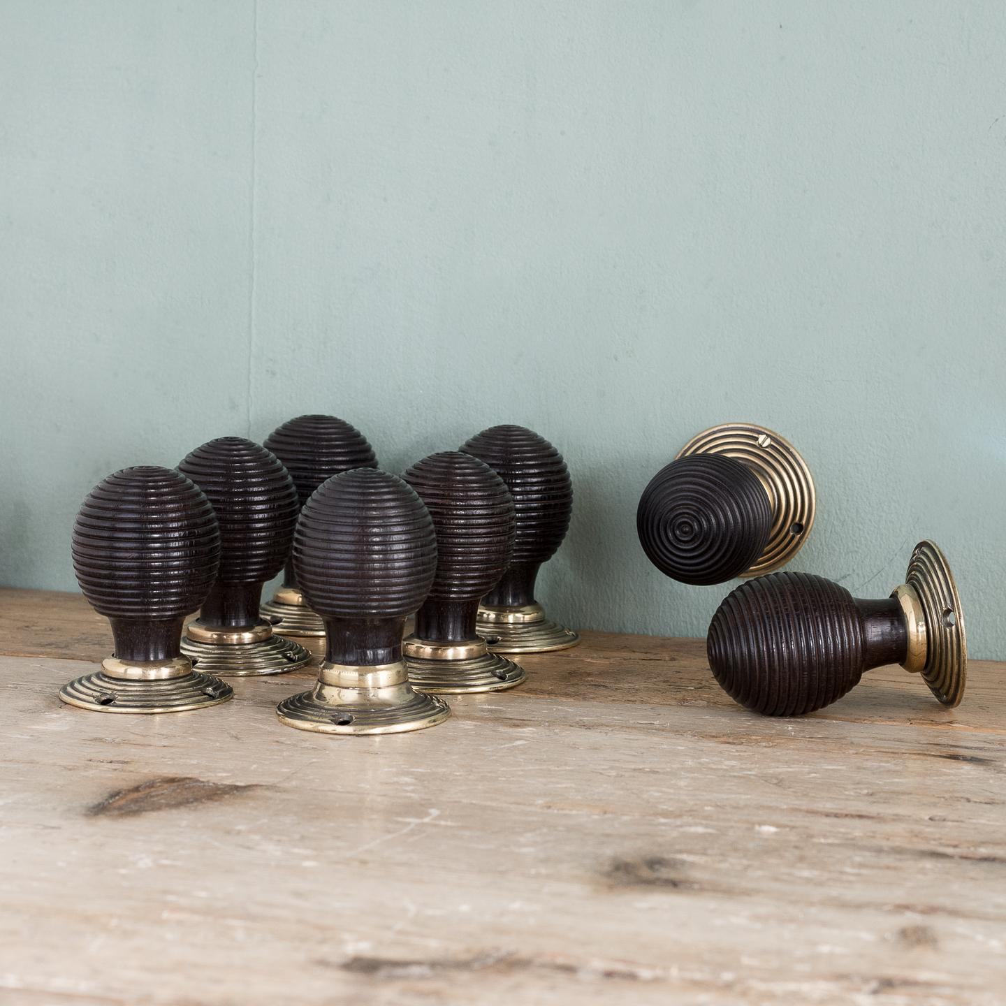 Victorian ebony beehive door knobs, with reeded decoration to the body and the brass back-plates, four pairs available.