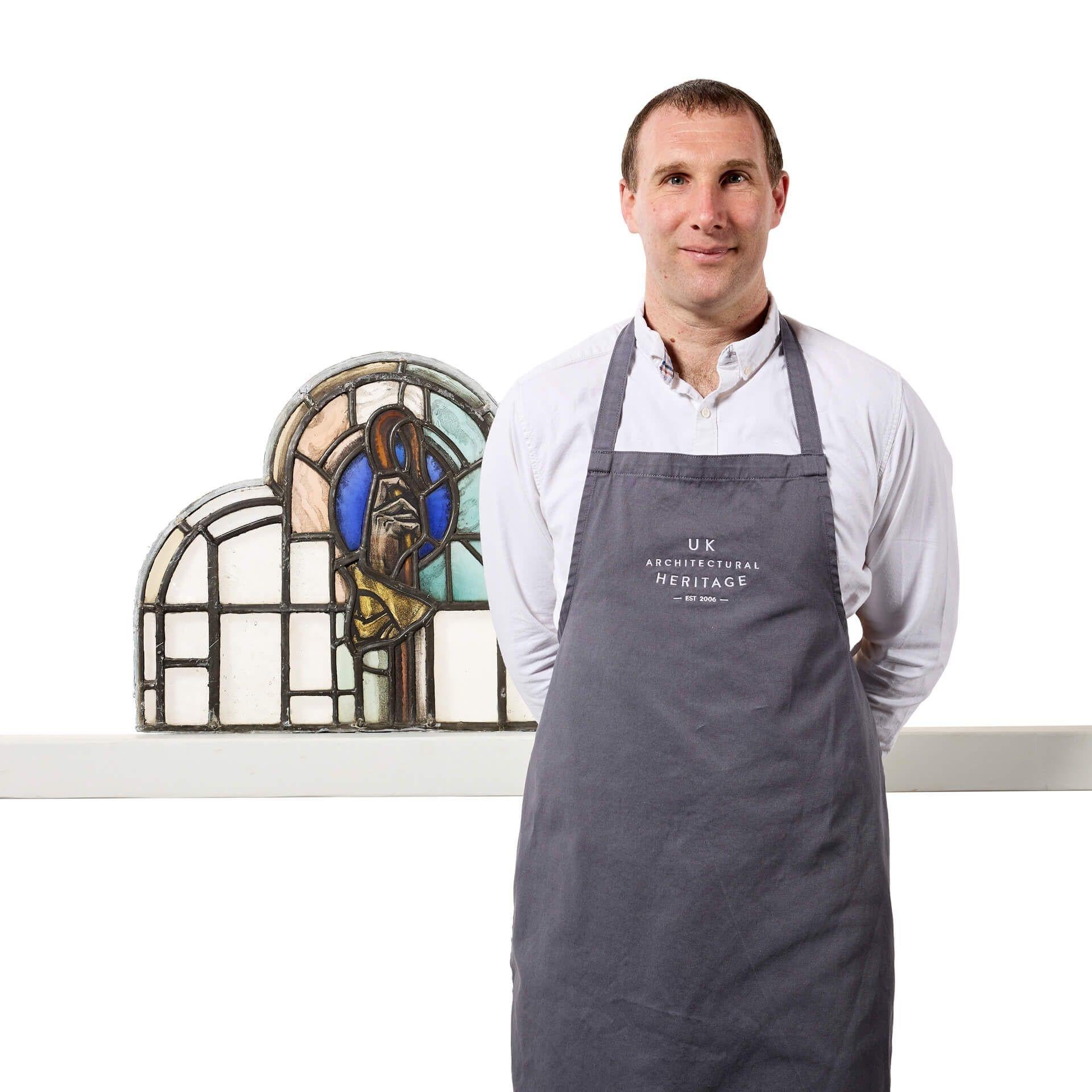 A simple yet elegant antique ecclesiastical multi-arched stained glass panel depicting a stylised shepherds crook.

Though it dates from the early 20th century, this will make a stunning feature above a porch or dividing door in properties