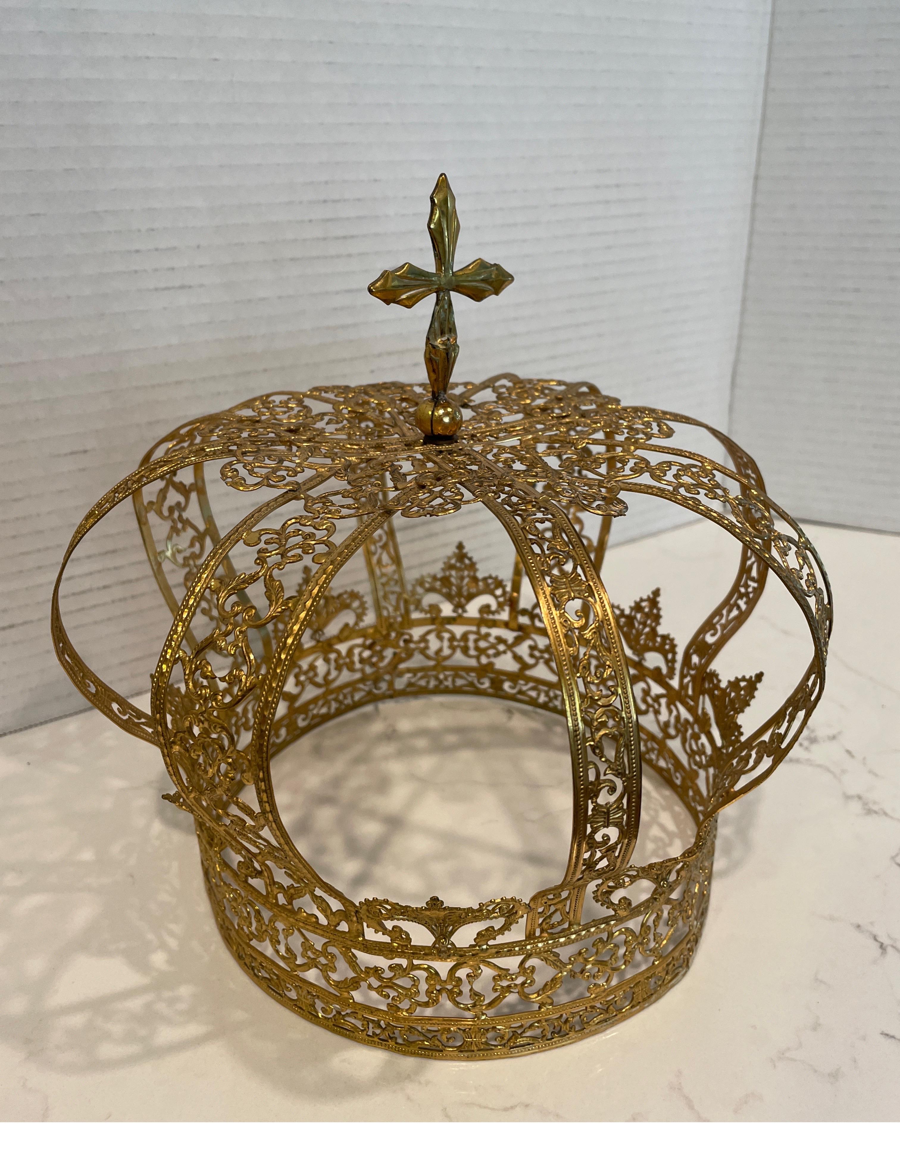 A gold tone religious Santos crown with stones embedded.