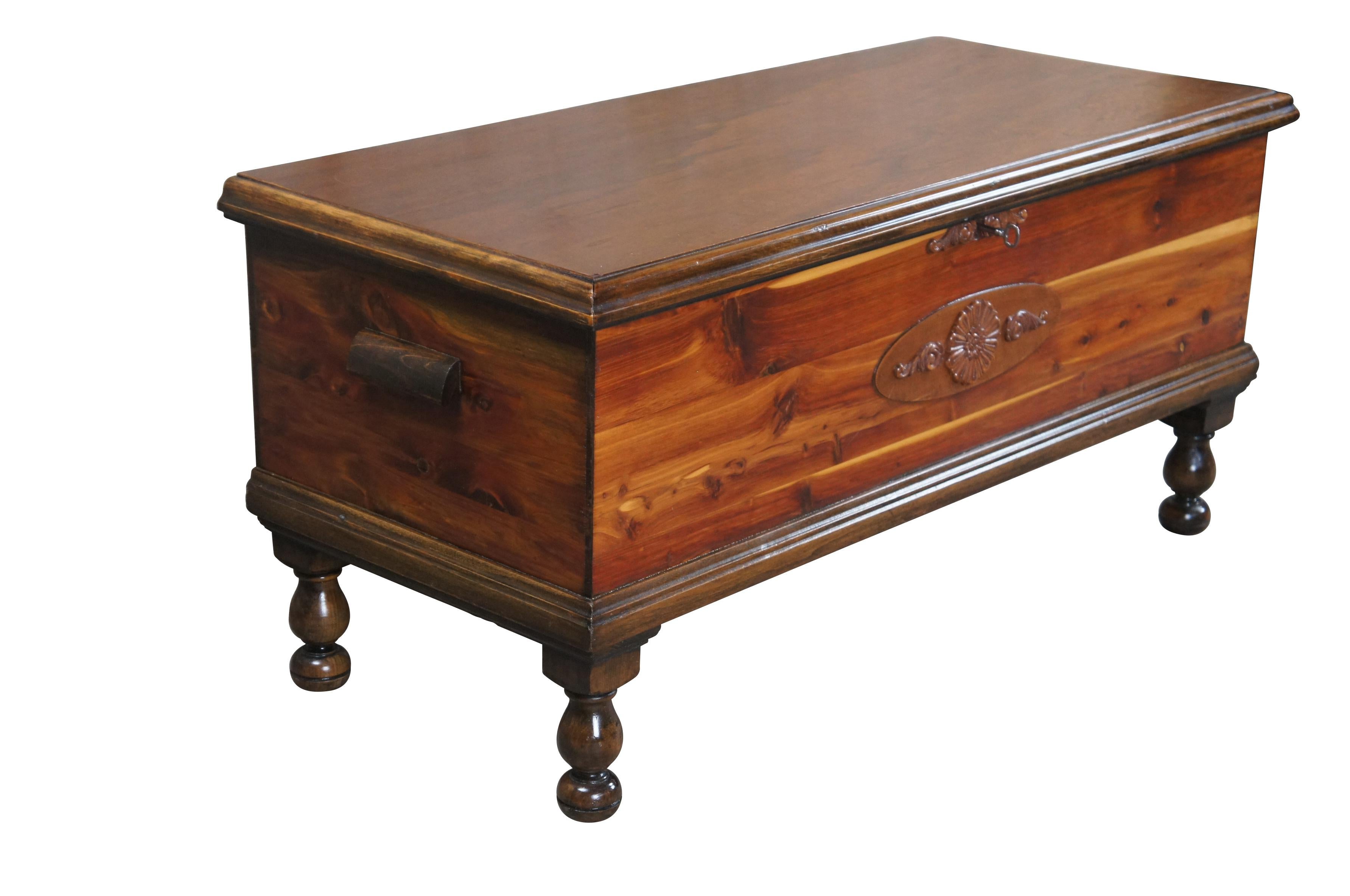 An antique cedar trunk by E.R. Co,  circa 1940s.  Features a primitive American Country design with footed base, carved embellishments along the front and handles at the sides.  The trunk is hinged and cedar lined.  Part of E.R. Co's Forest Park