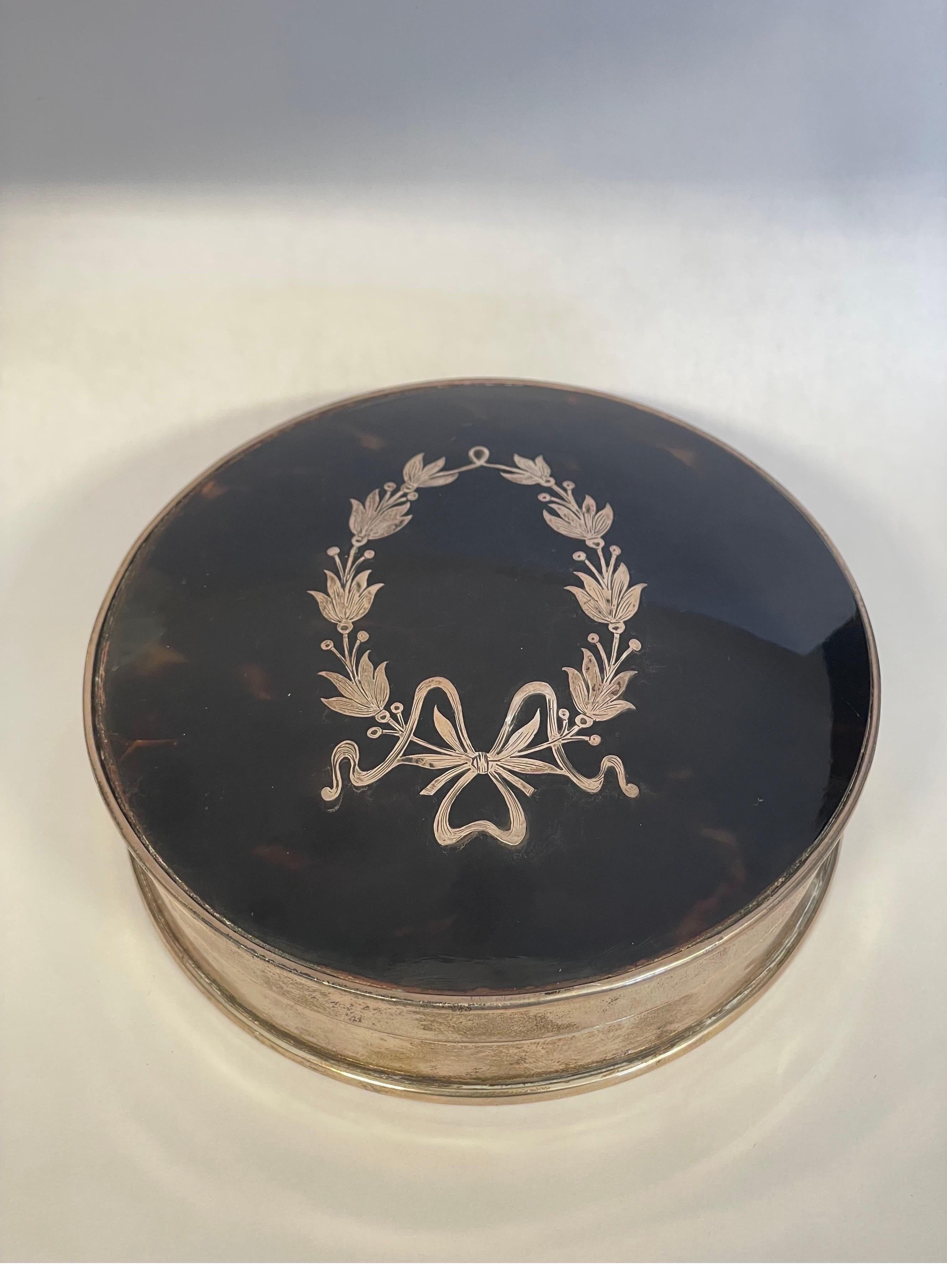 An 1894 antique Edward Souter Barnsley & Co. sterling silver and tortoiseshell powder box decorated with a silver laurel leaf and bow inset to the top. Marked appropriately to the side.