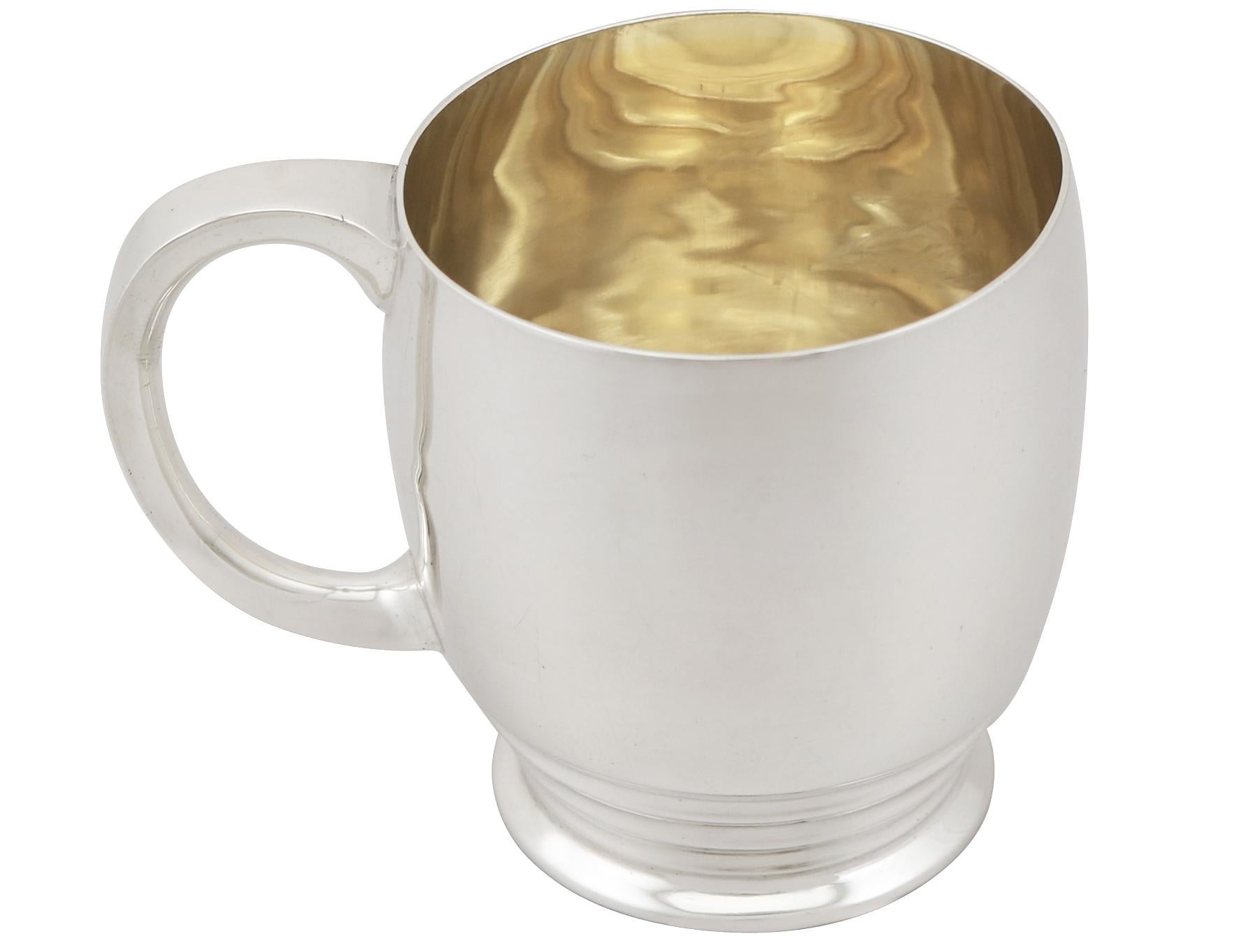 A fine and impressive antique Edward VIII English sterling silver christening mug in the Art Deco style; an addition to our Art Deco silverware collection.

This fine antique Edward VIII sterling silver christening mug has a plain circular rounded