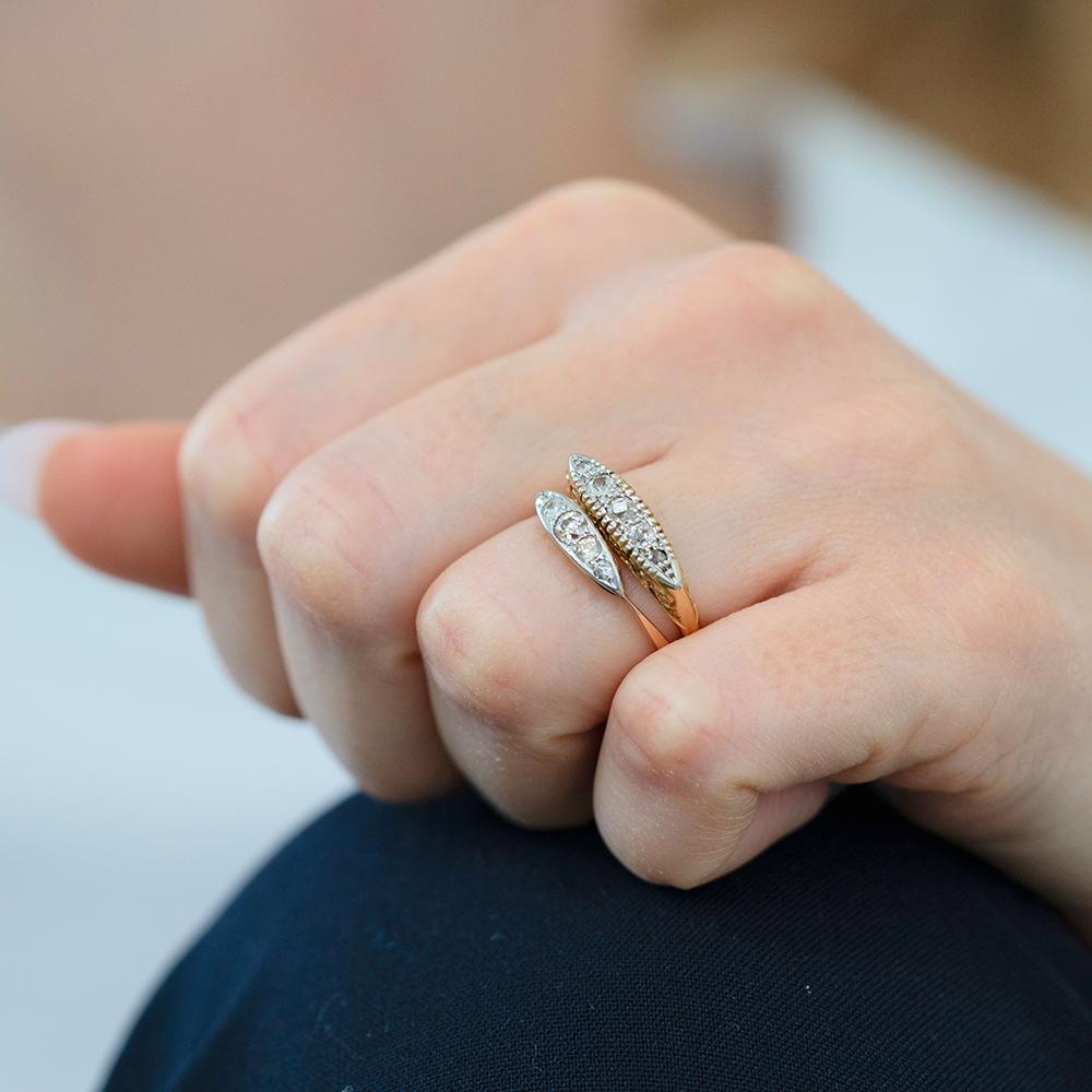 Classico ed elegante pezzo di gioielleria vittoriana, questo antico anello con cinque pietre e diamanti è realizzato in oro giallo 18 ct con una montatura a navette in platino. La fascia è sottile e affusolata, per attirare l'attenzione sul display
