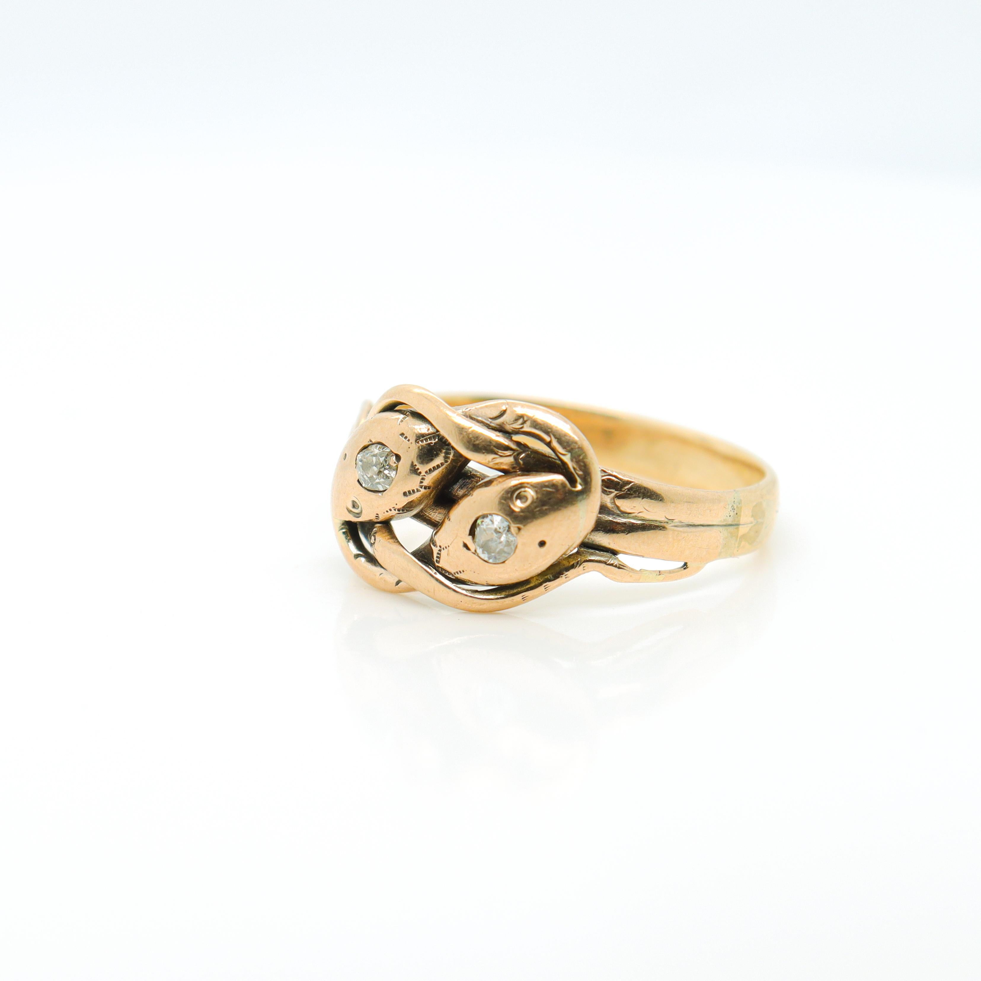 A fine antique gold & diamond figural snake ring.

In 14K gold.

In the shape of 2 intertwined snakes. 

Each pave set with a round single cut diamond to their heads and traces of an etched design.

Simply a wonderful late Victorian