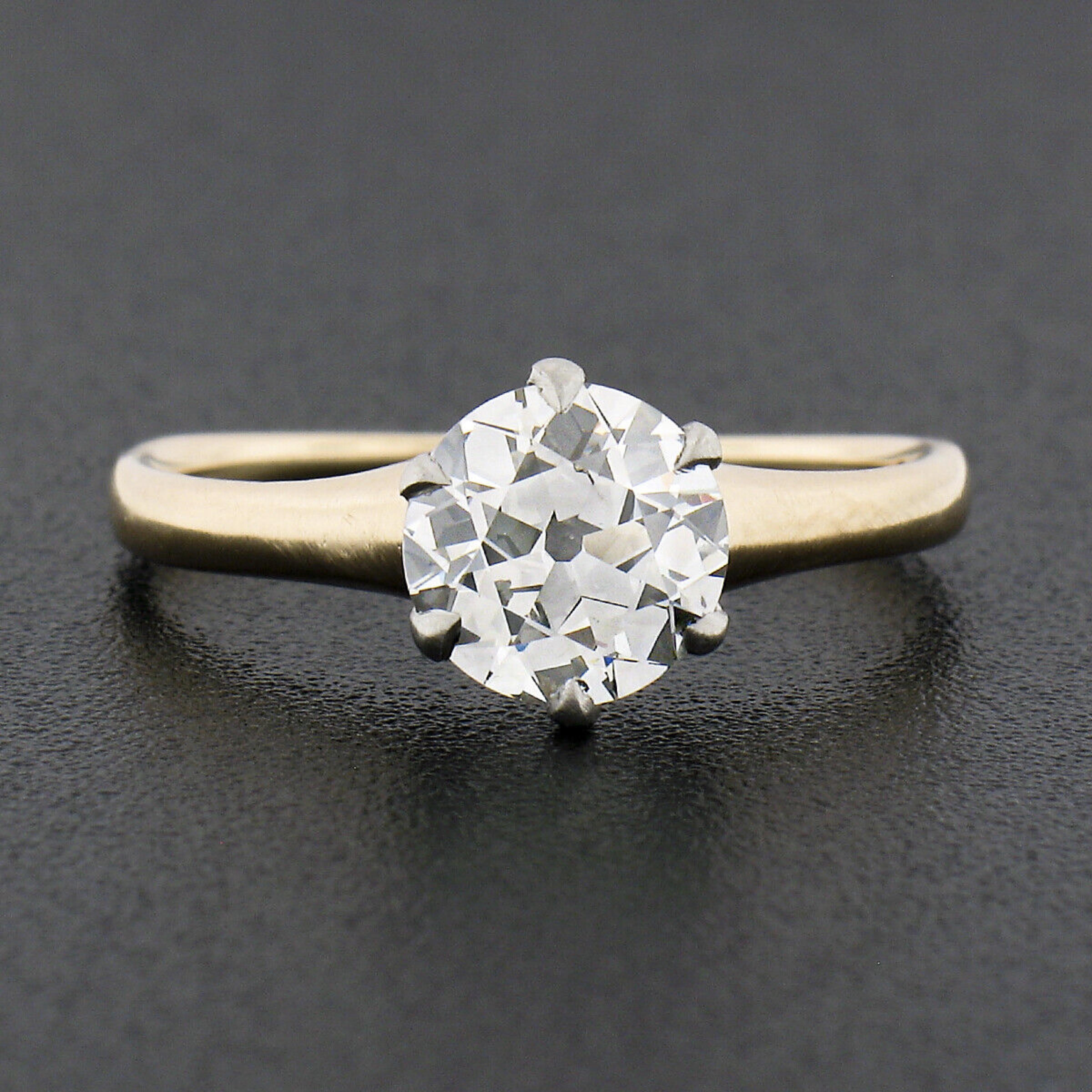 This stunning antique solitaire engagement ring was crafted in solid 14k yellow gold and platinum during the Edwardian period and features an outstanding old European cut diamond perfectly 6-prong set at its center. The GIA certified diamond weighs