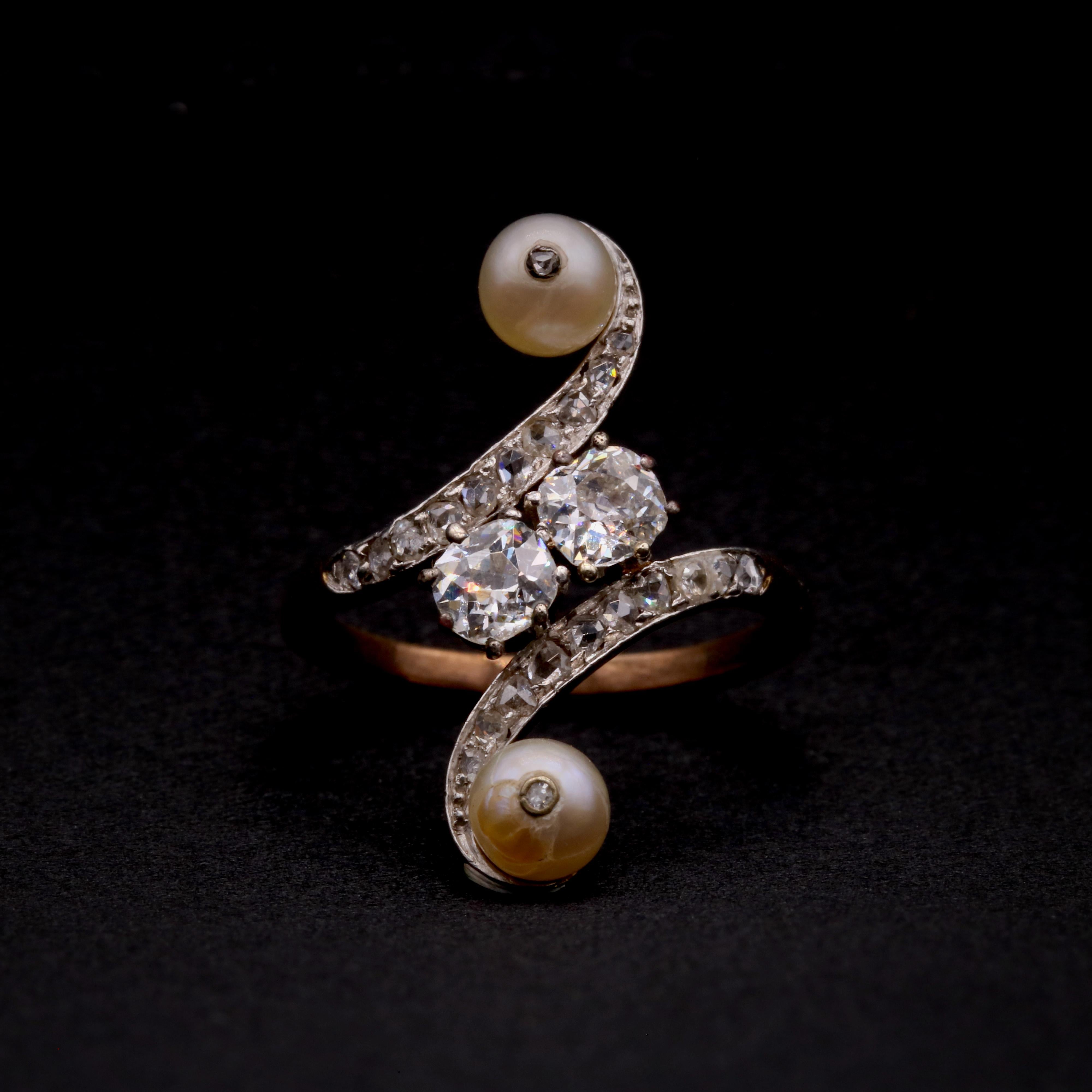 Anillo antiguo de diamantes, perlas, platino y oro amarillo, compuesto por dos grandes diamantes talla mina antiguos, veintidós diamantes talla rosa y dos perlas, engastados en platino y oro amarillo de 14 quilates, a una banda de oro amarillo de 14