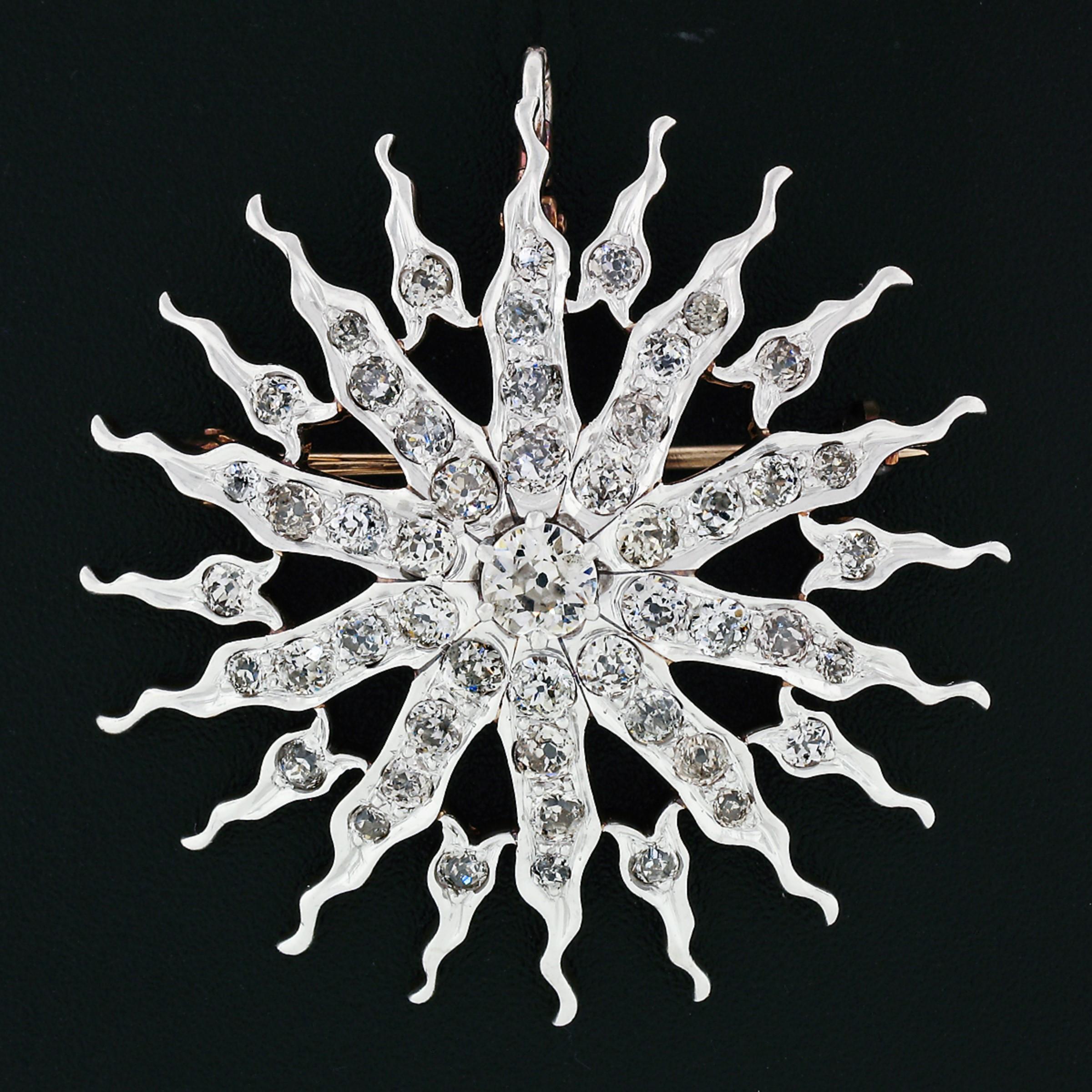 This gorgeous antique brooch/pendant was crafted during the Edwardian era from solid 14k gold and platinum top. It features a large, approximately 0.40 carats old European cut diamonds prong set at the center of the large sunburst design. The wavy