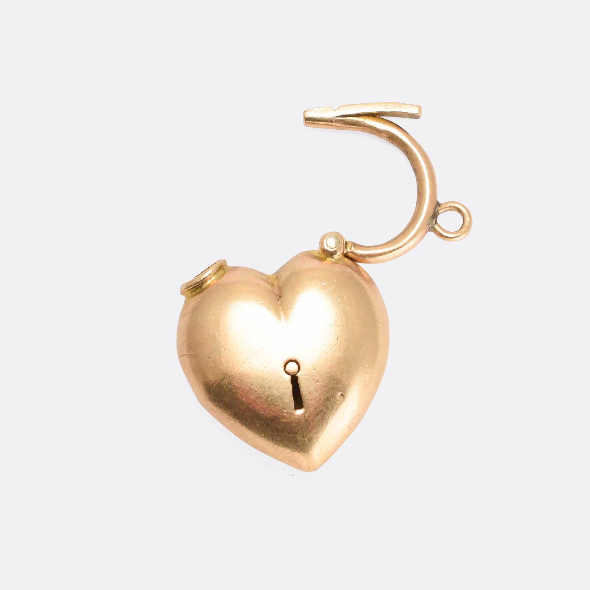 A fine Edwardian puffed heart padlock pendant modelled in 15 karat yellow gold. The top opens for easy attachment (it was likely intended to be worn as a bracelet clasp), and the frond features a keyhole.... suggesting the sentiment 