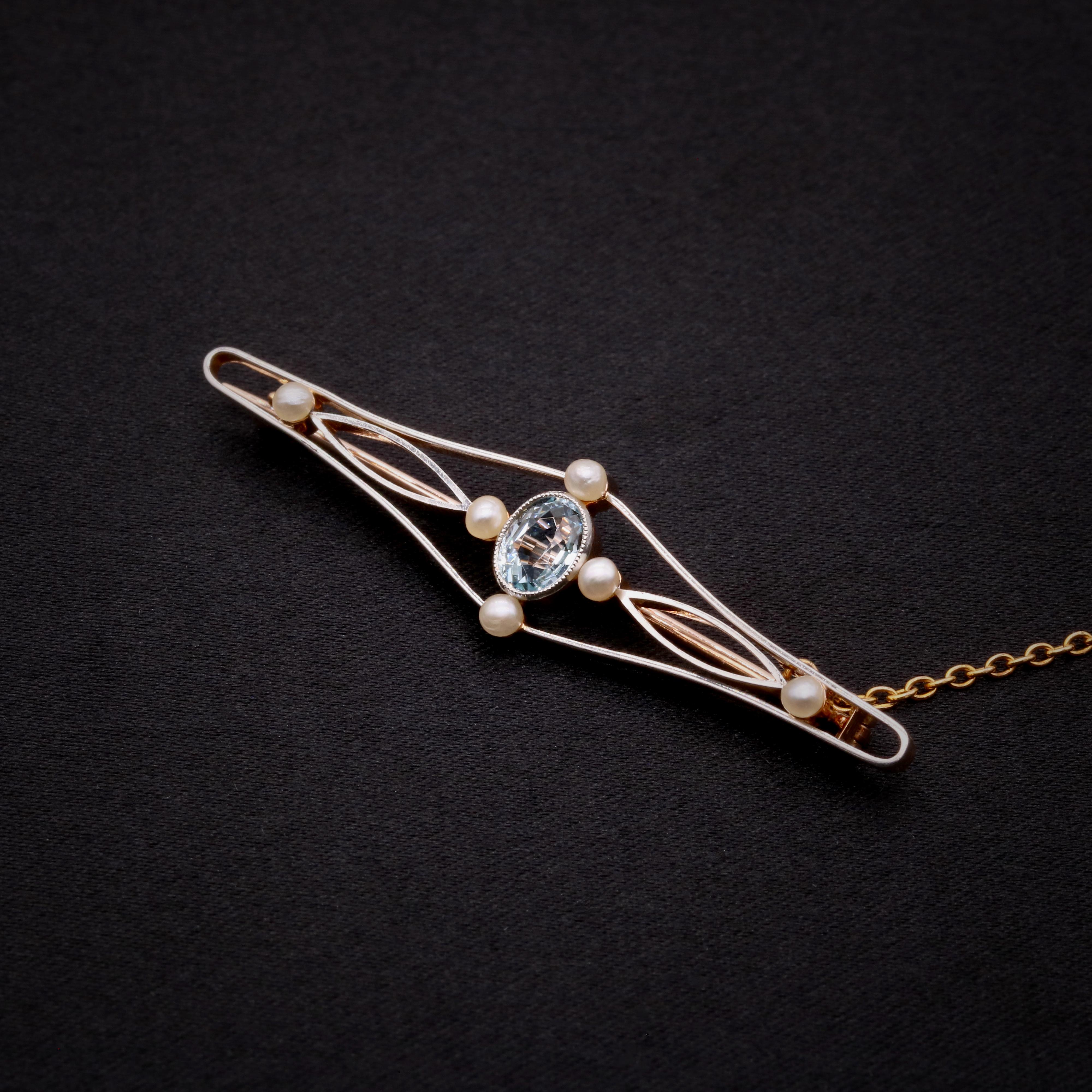 An Edwardian aquamarine, pearl, white and yellow gold brooch, comprising one oval cut aquamarine, and six seed pearls, set in 15 karat yellow gold, with 15 karat yellow gold pin and fittings.  

This elegant Edwardian brooch is centred upon an oval