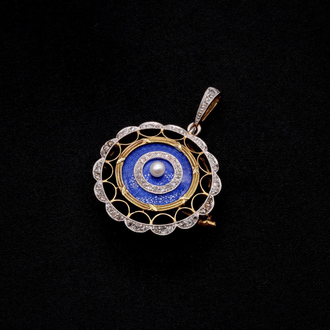 An Edwardian guilloche enamel, diamond, pearl, platinum, and yellow gold brooch and pendant, comprising one seed pearl, sixty-five rose cut diamonds and a panel of blue enamel, set in platinum, and backed in 15 karat yellow gold, with yellow gold