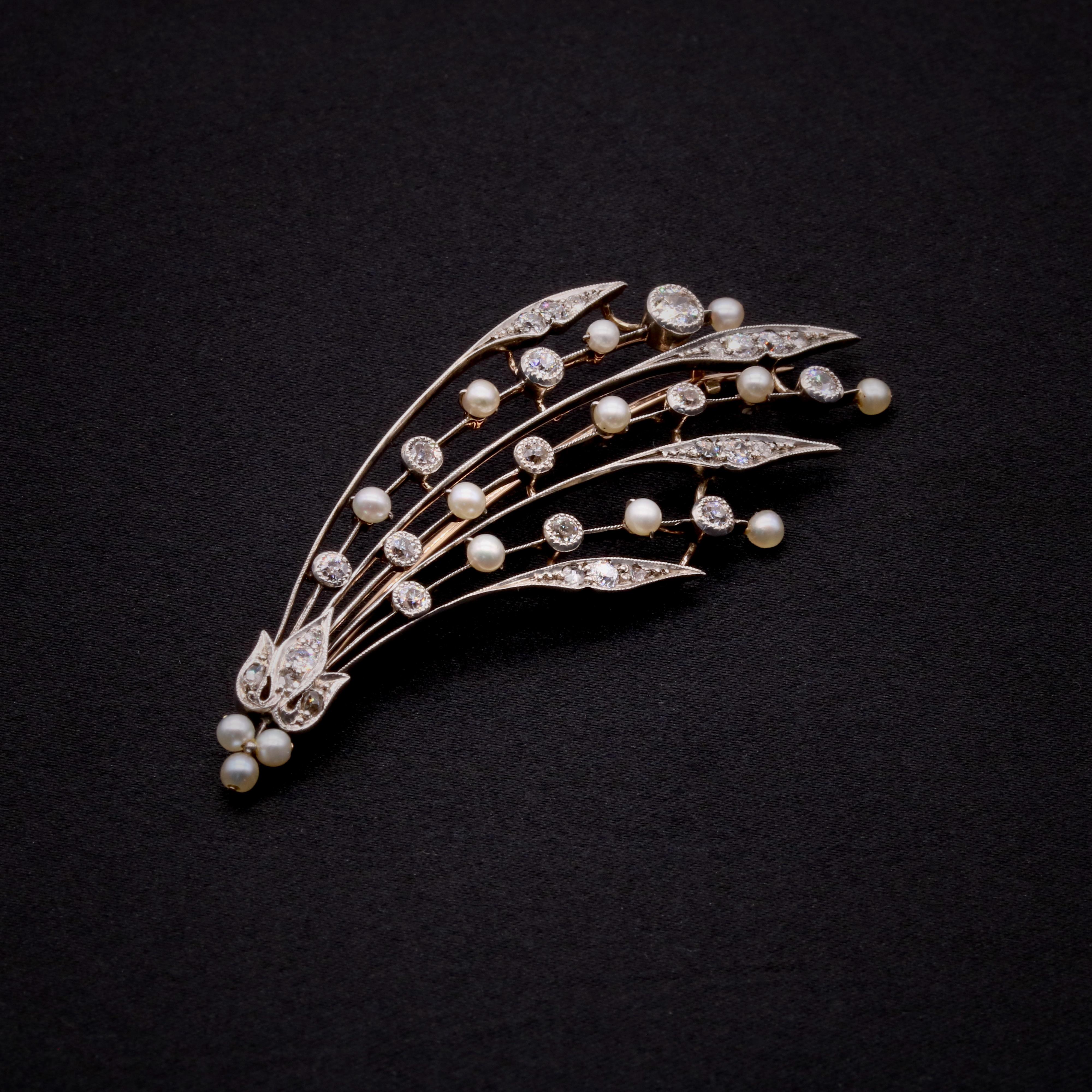 An Edwardian diamond, pearl, silver, and yellow gold brooch, comprising twenty-two old European cut diamonds, six rose cut diamonds, and fourteen seed pearls, set in silver, backed in 15 karat yellow gold, with 15 karat yellow gold pin and fittings.