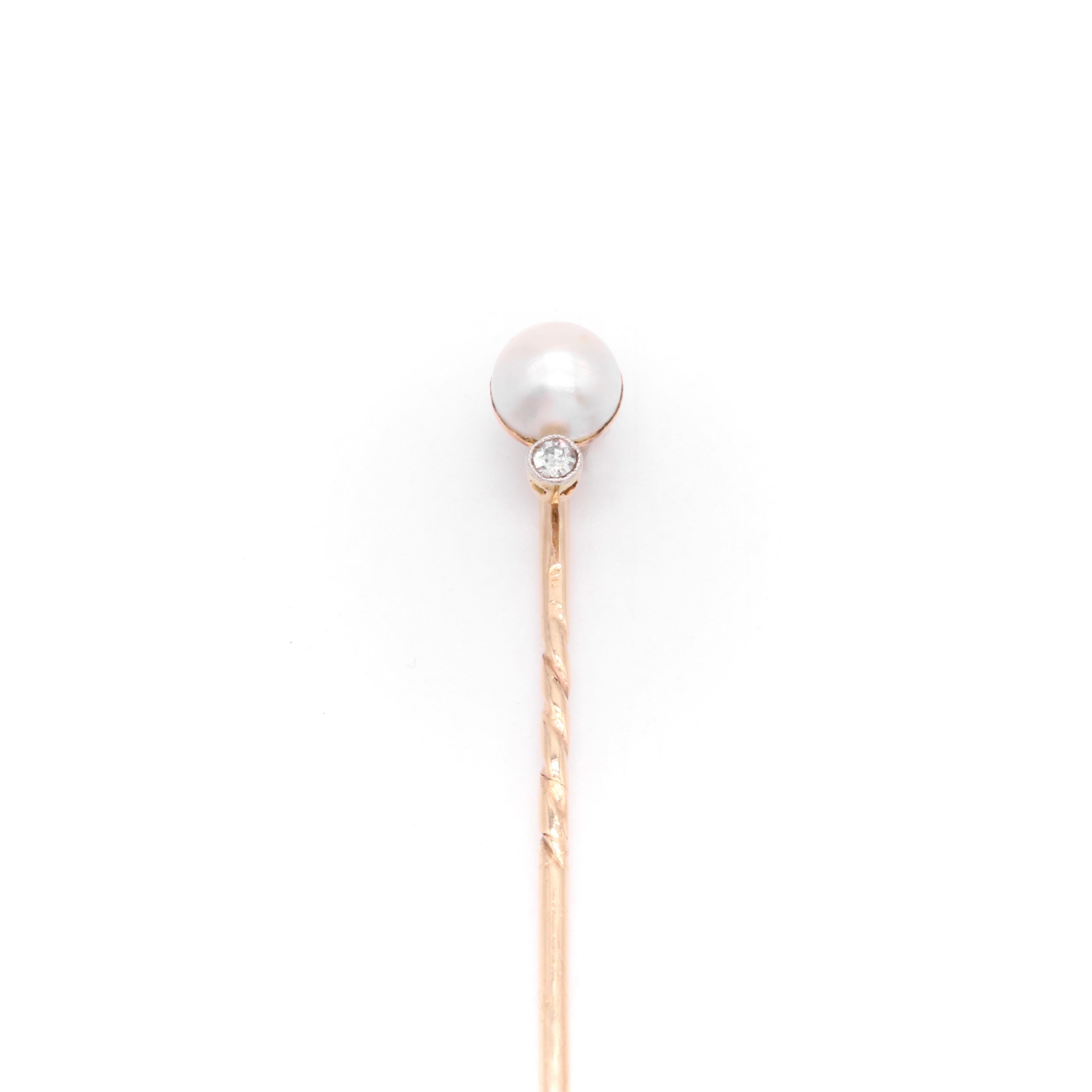An Edwardian diamond, pearl, platinum, and yellow gold stick pin, comprising one old single cut diamond, and one button pearl, set in platinum and 15 karat yellow gold, with a 9 karat yellow gold pin. 

This endearing stick pin is set with a round,