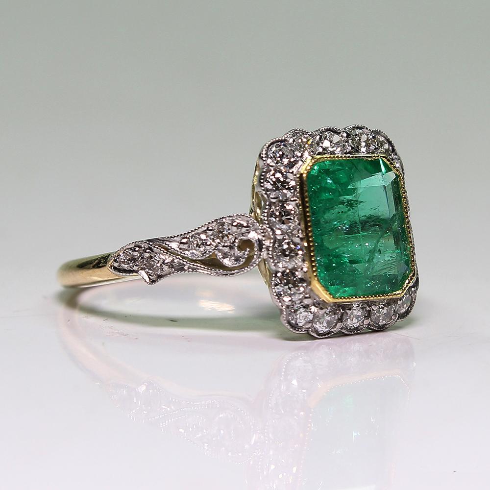 Period: Edwardian (1901-1920)
Composition: 18K gold and platinum.

Stones:
•	1 natural Colombian cut emerald that weighs 1.69ctw.
•	26 Old mine cut diamonds of G-VS2 quality that weigh 0.75ctw.
Ring size: 7 ½   
Ring face:  12mm by 11mm 
Rise above