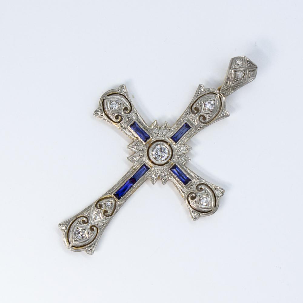Period: Edwardian (1901-1920)
Composition: 18K gold and platinum 
Stones:
•	1 Old mine cut diamond of H-VS2 quality that weighs 0.15ctw 
•	8 Single cut diamonds of H-SI1 quality that weigh 0.10ctw. 
•	5 natural French cut sapphires that weigh