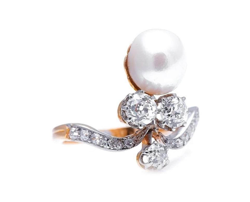 Natural pearl and diamond ring, circa 1900. Set with an ornate arrangement of late 19th century circular-cut diamonds, the centrepiece of this ring is an oval natural saltwater pearl of superb quality, with a cream body colour and a beautiful,